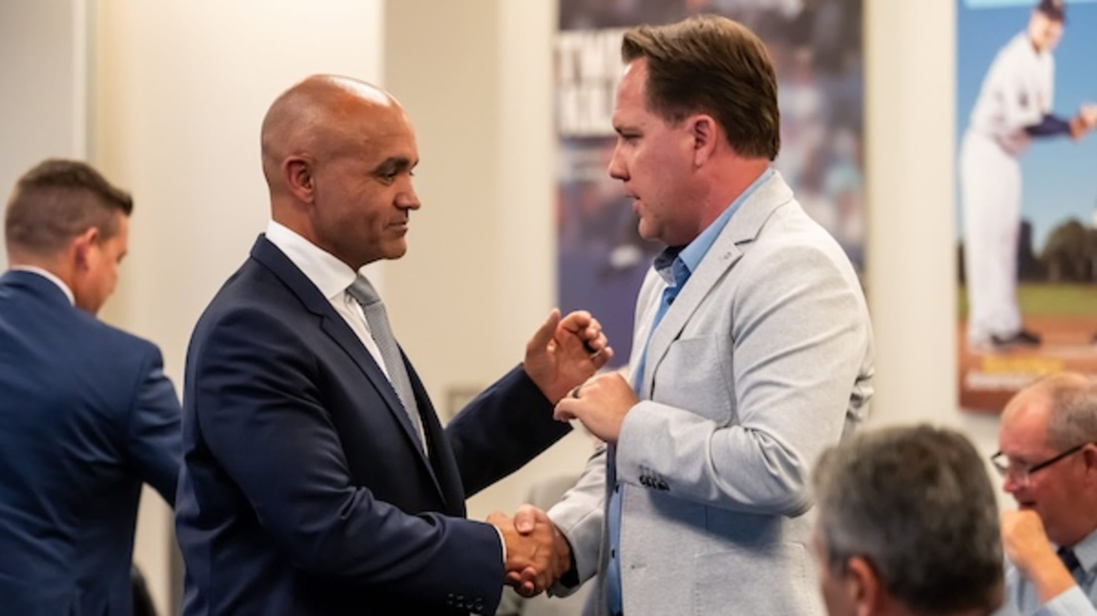 Twins President Derek Falvey and Assistant General Manager Sean Johnson shaking hands.