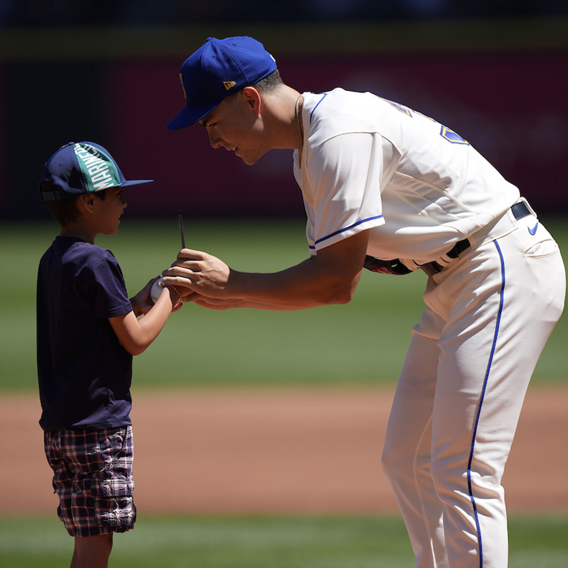 Bryan Woo signing autograph for young fan.
