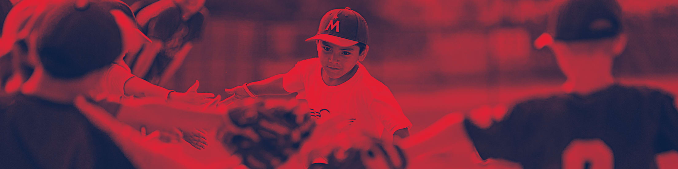 A boy wearing a Twins cap high-fiving teammates
