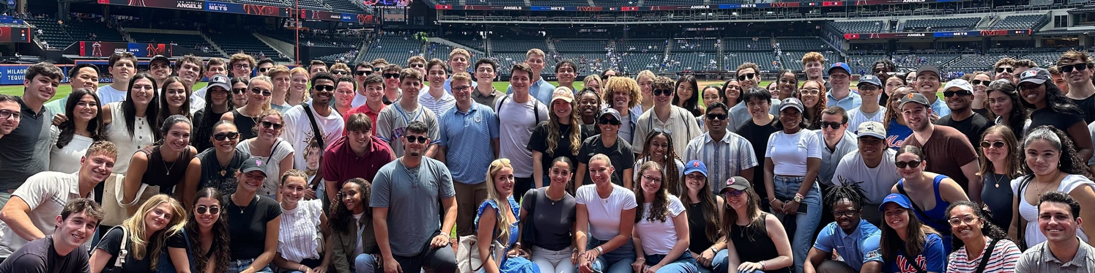 MLB interns stand on the field at a Mets game at Citi Field.