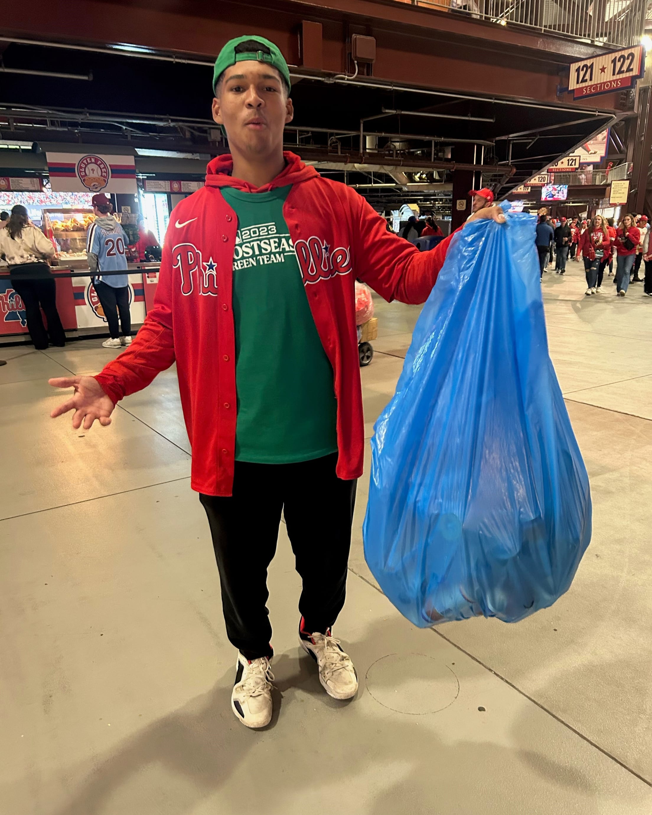 A Green Team member holds a bag of recyclables during a postseason game at Citizens Bank park.