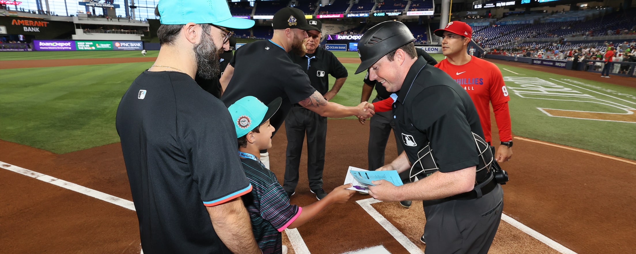 Fans delivering the lineup card to the umpire at a Marlins game