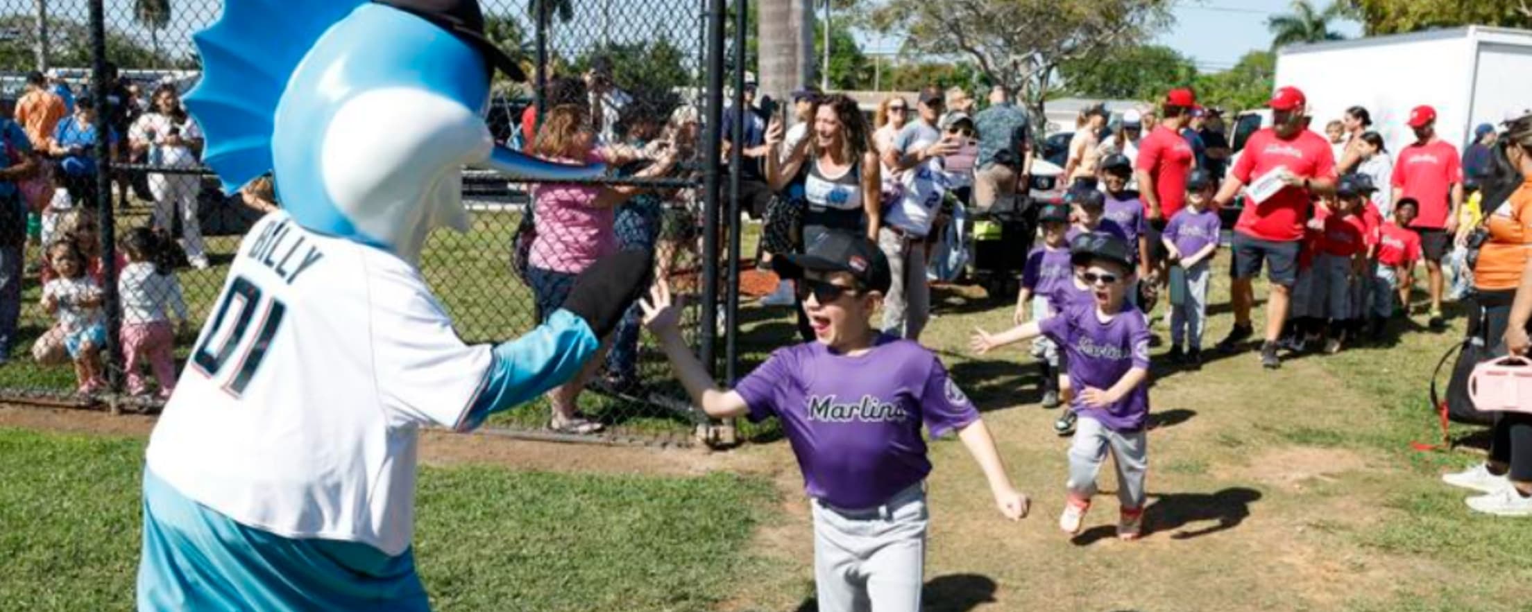 Tee ball players high-fiving Billy the Marlin