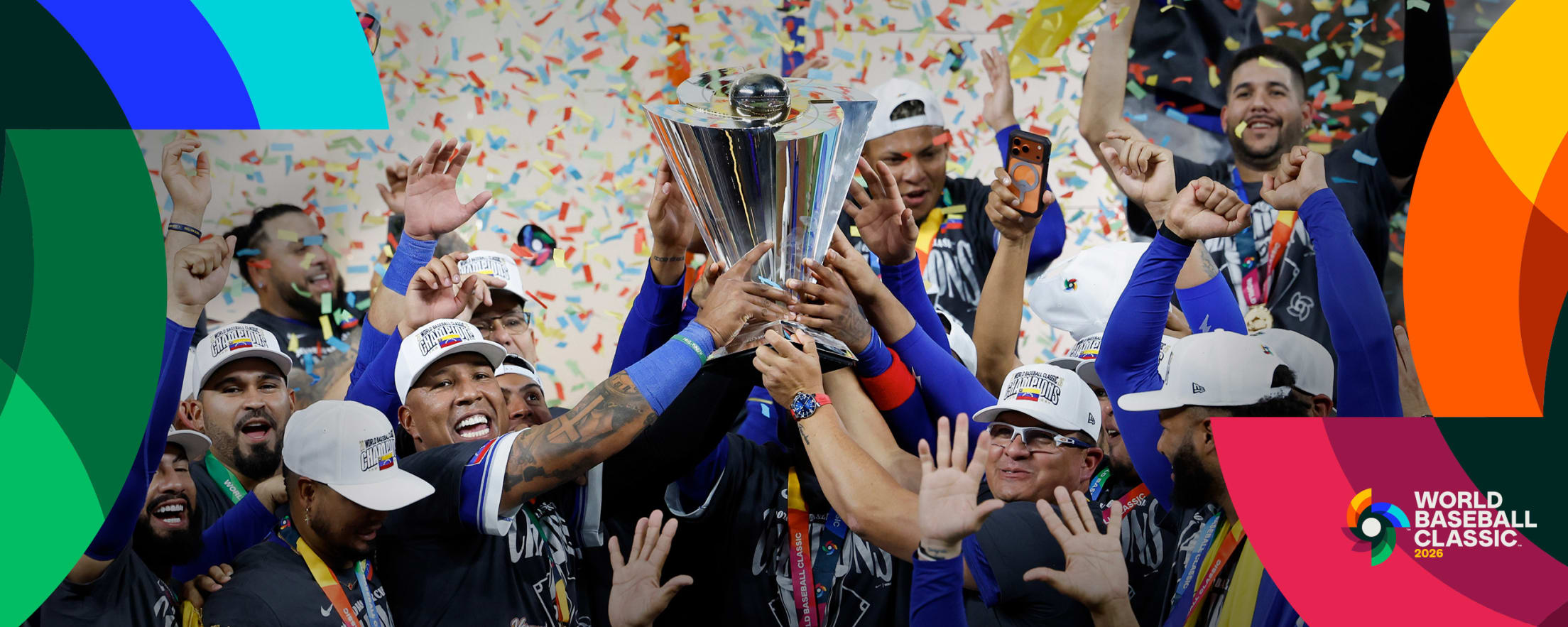 Team Venezuela catcher Salvador Perez and manager Omar López hold the World Baseball Classic trophy in celebration after winning the 2026 tournament.