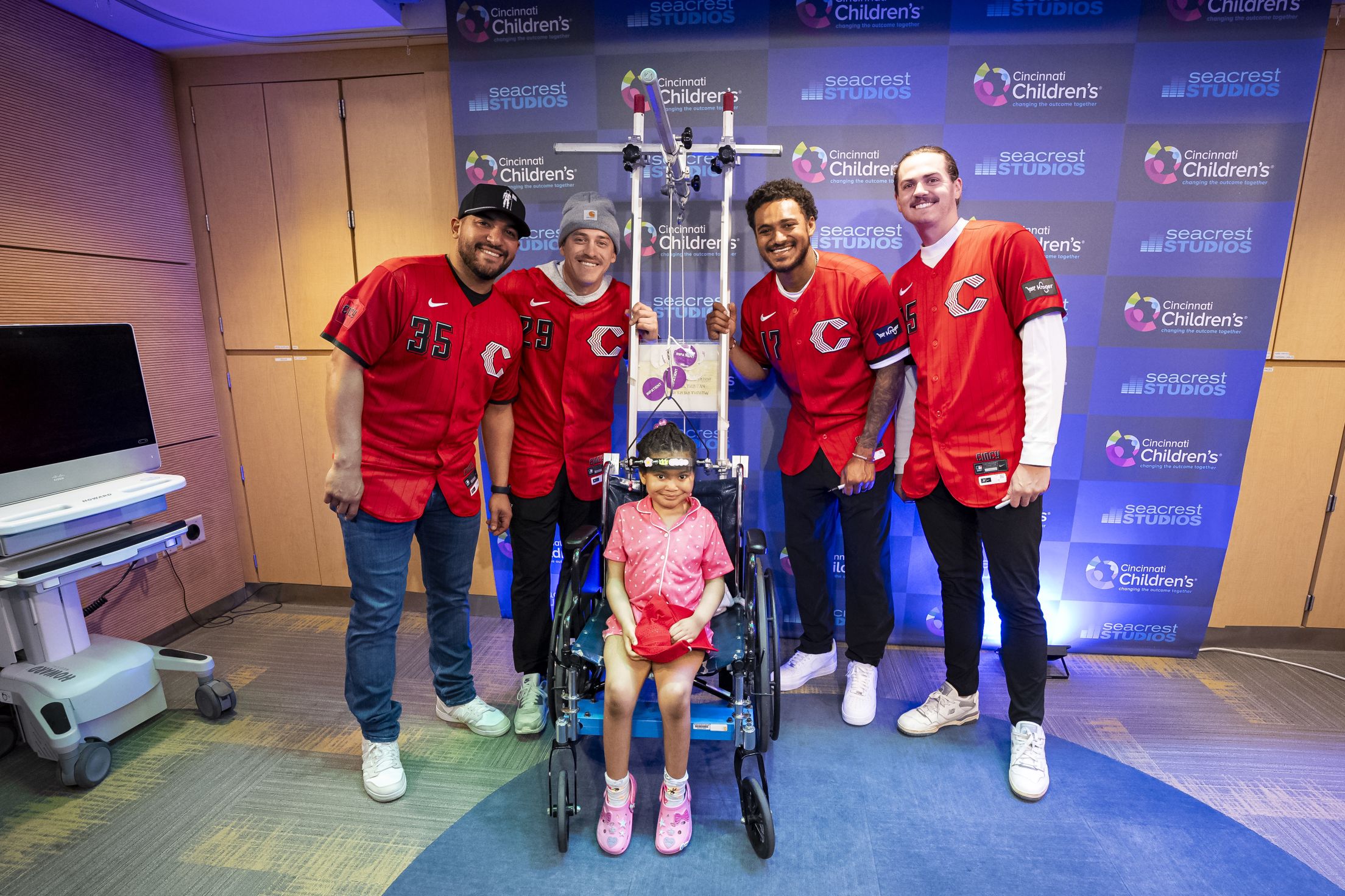Jose Trevino and teammates take a picture with a young child at the Children's Hospital.