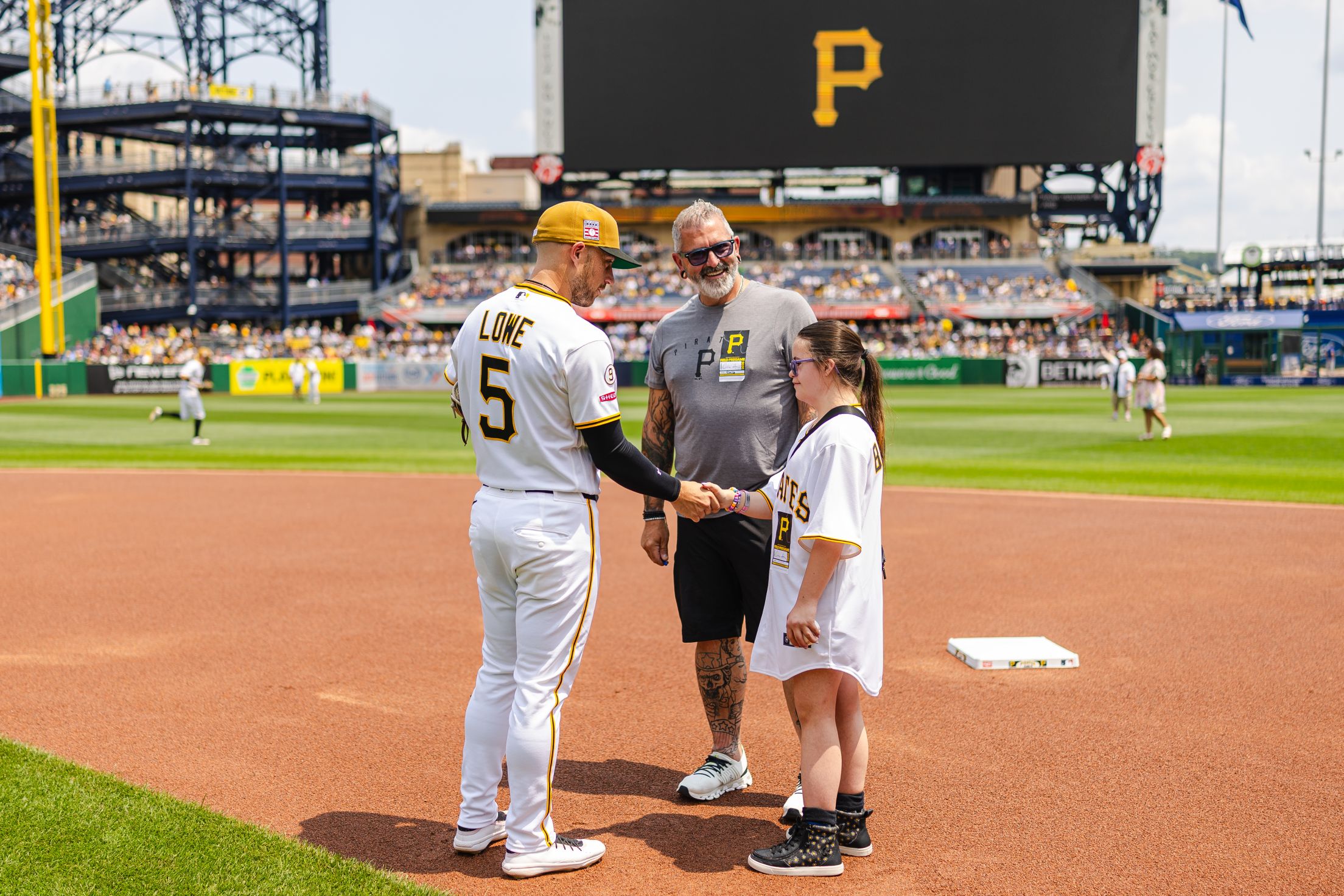 Brandon Lowe shakes hands with a Pittsburgh Pirates fan on the field at PNC Park.