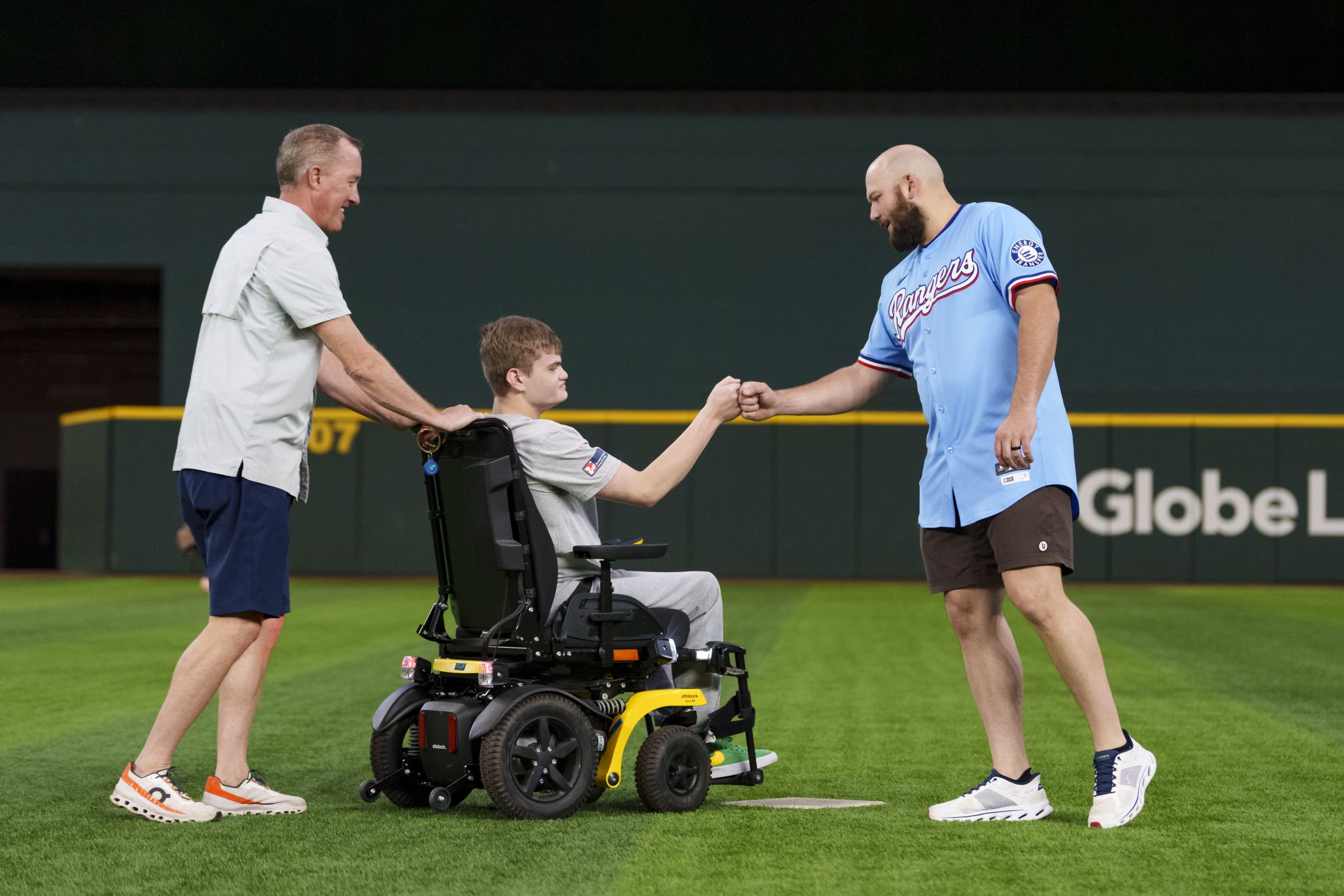 Jake Burger fist bumps a fan during the Make-A-Wish Field Day at Globe Life Field.