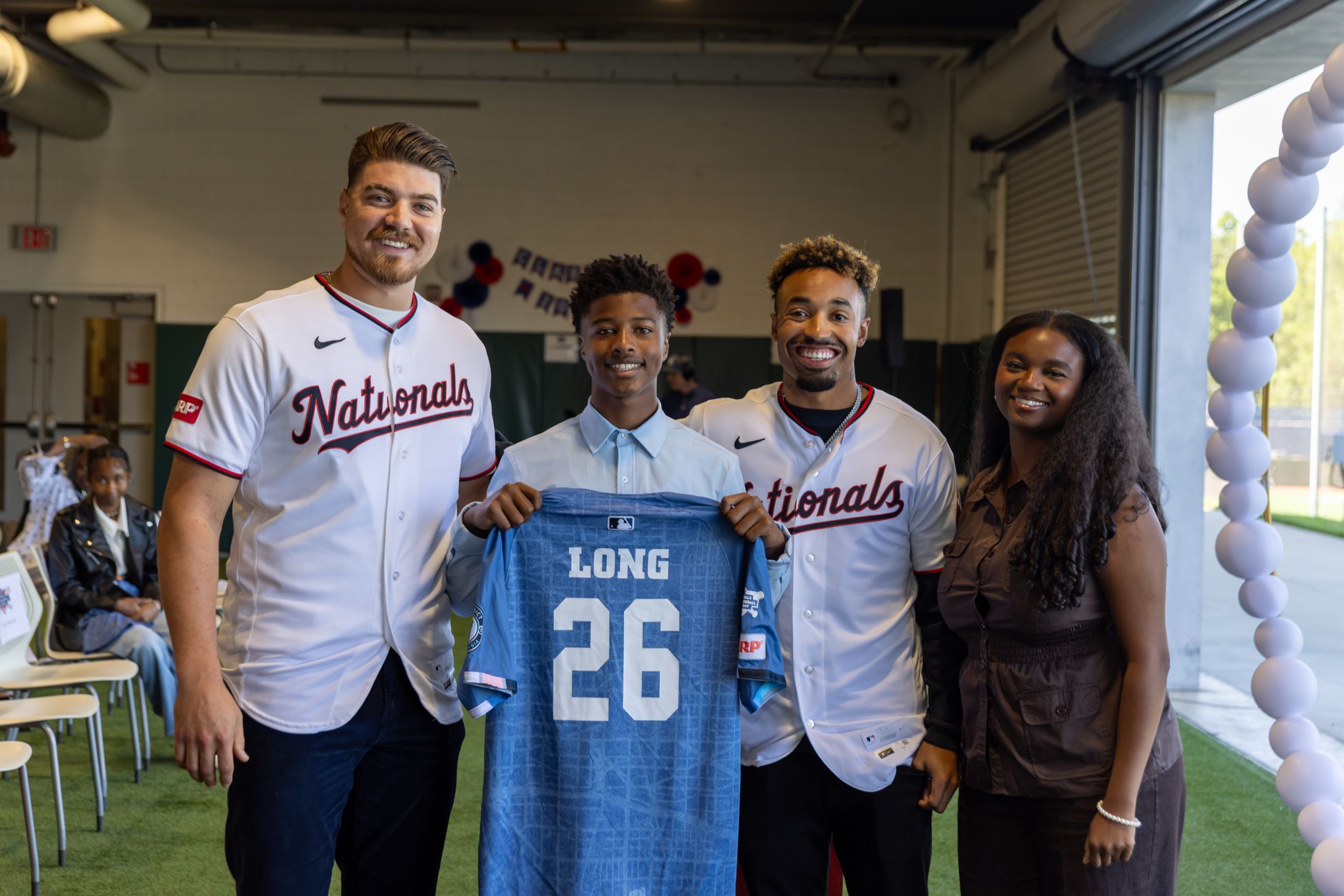Nasim Nuñez and Case Cavalli take a picture with a student from the Nationals Youth Baseball Academy (YBA).
