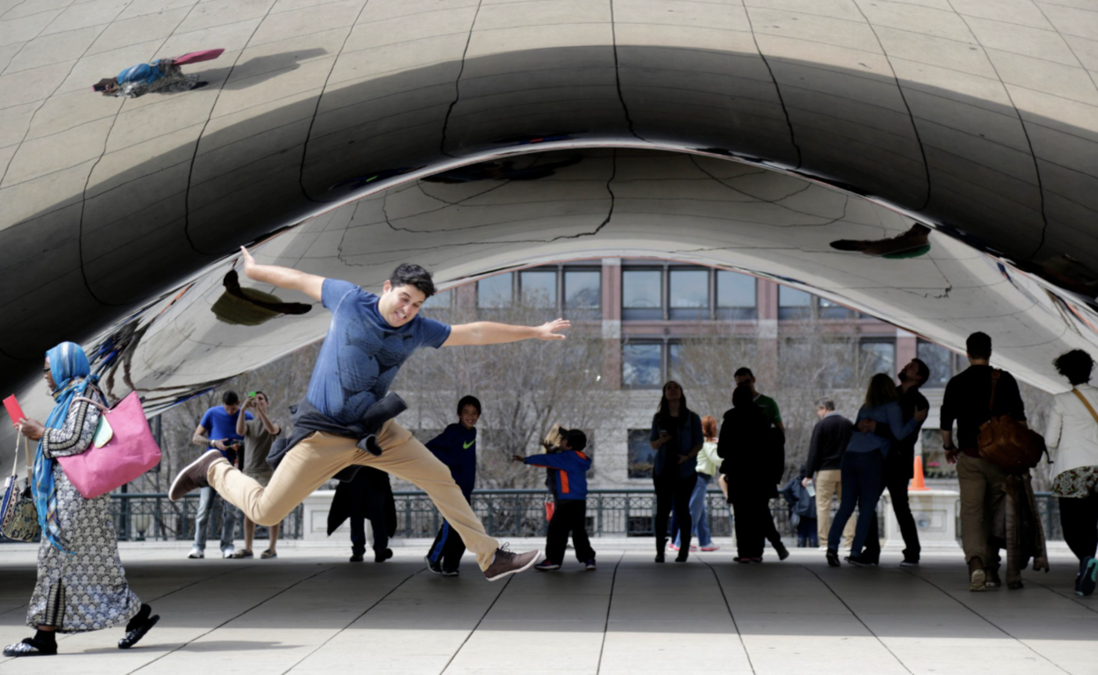 man-jumping-playfully-in-front-of-cloud-gate-mirrored-sculpture-chicago