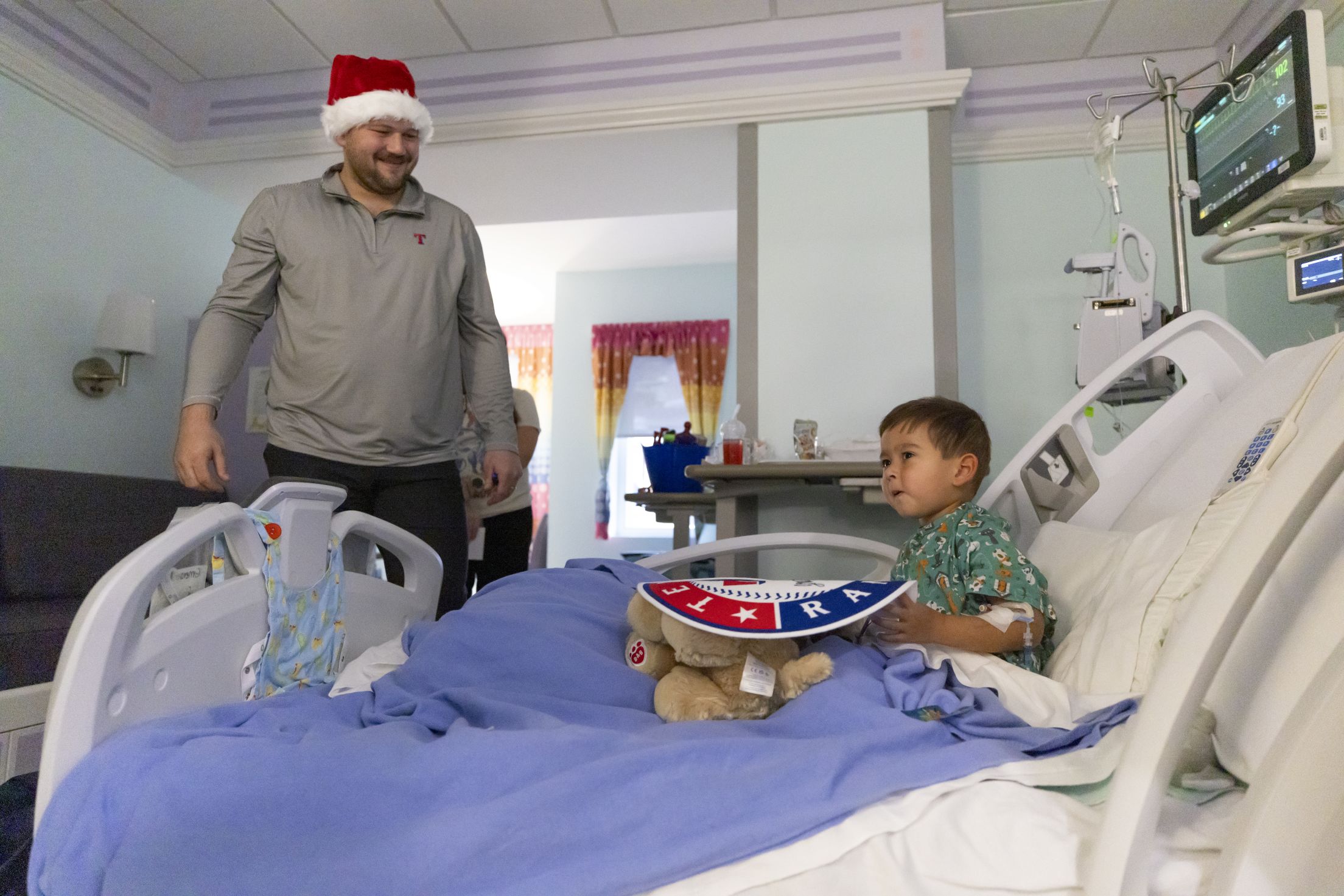 Jake Burger visits a young Texas Rangers fan at the hospital.