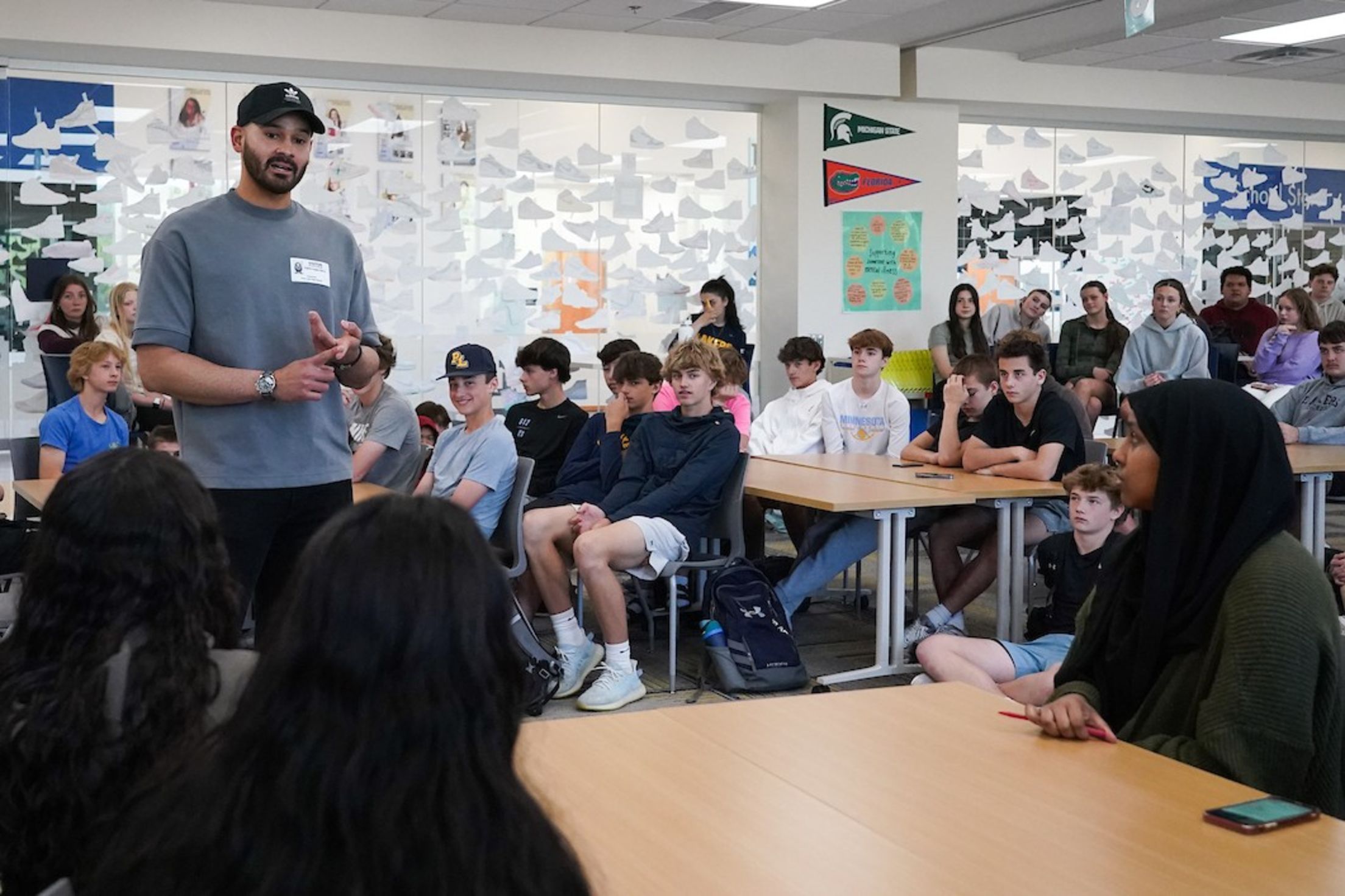 Pablo López speaks with students at a high school.