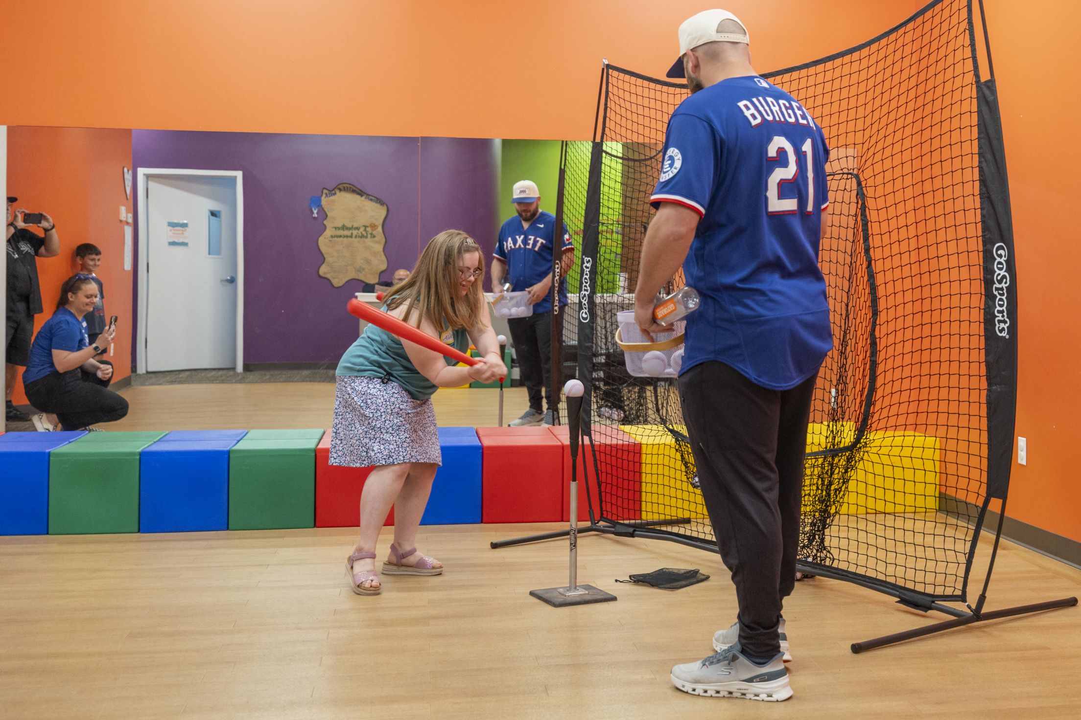 Jake Burger plays t-ball with a girl at Gigi's Playhouse.