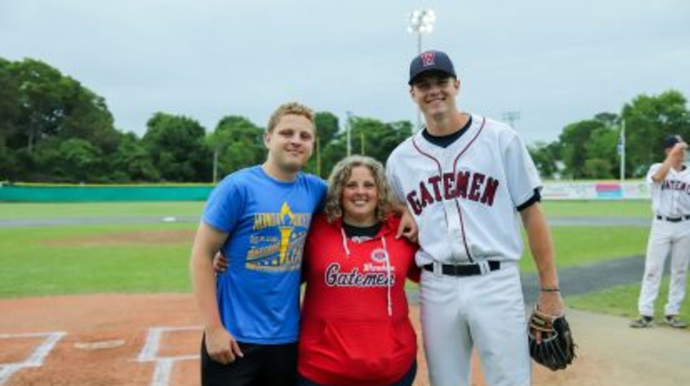 Wareham Gateman player stands near home plate with his host family.