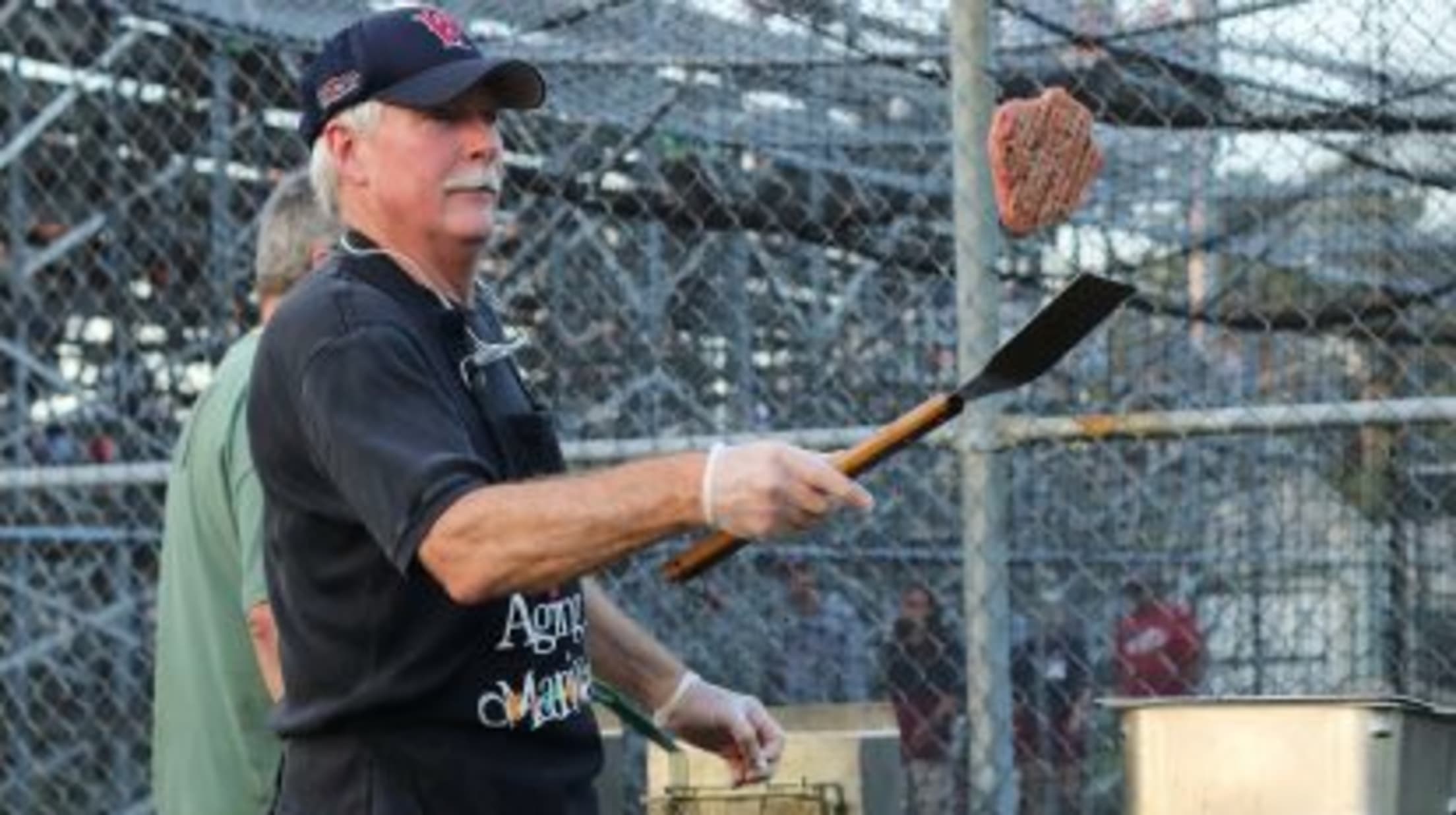 Wareham volunteer flips a burger on a grill at the ballpark.
