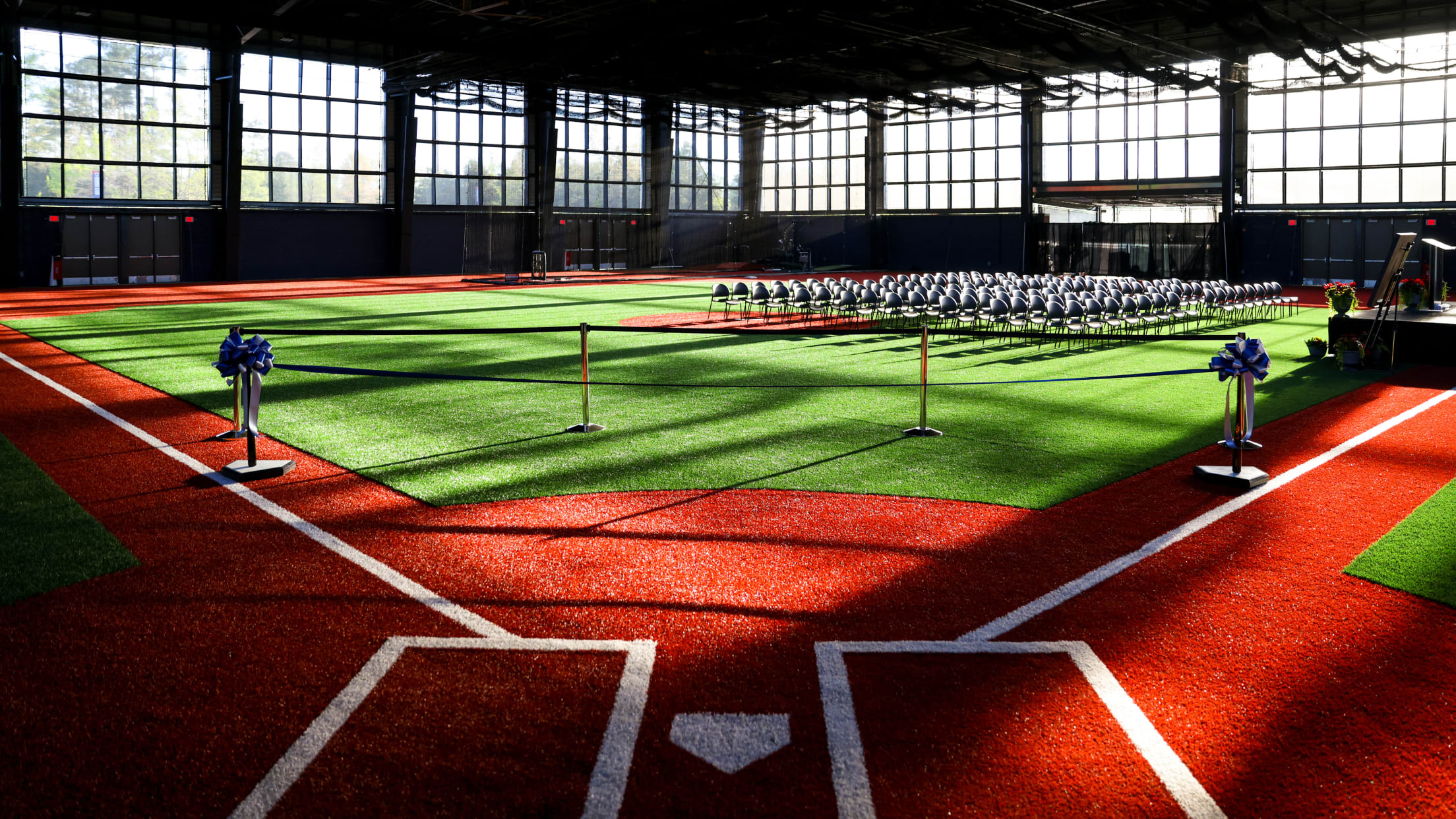 An indoor field at the National Training Complex with a stage and seats set up for an event.