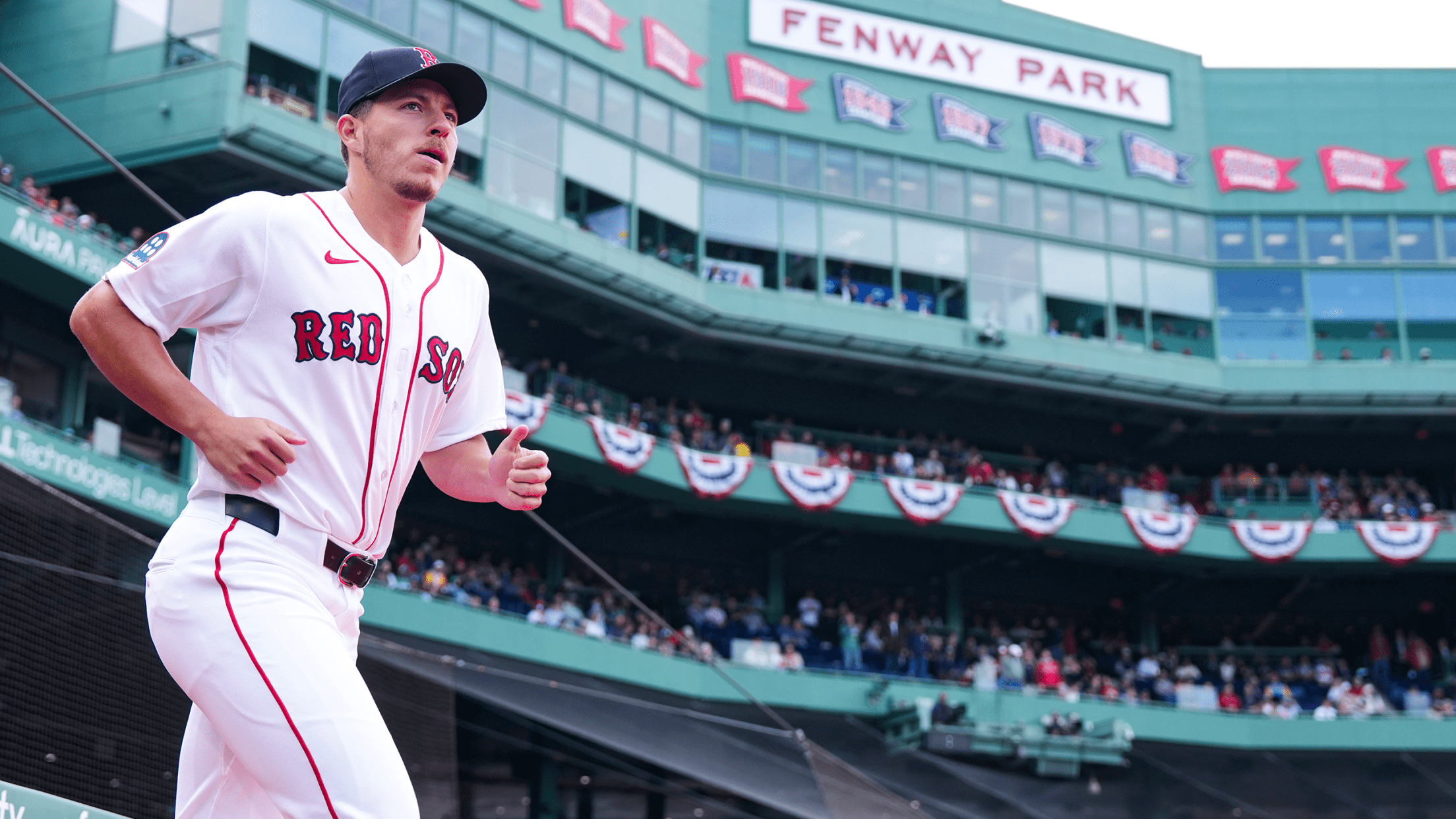 Tyler Uberstine jogs onto the field at Fenway Park in the Red Sox's white home uniform.