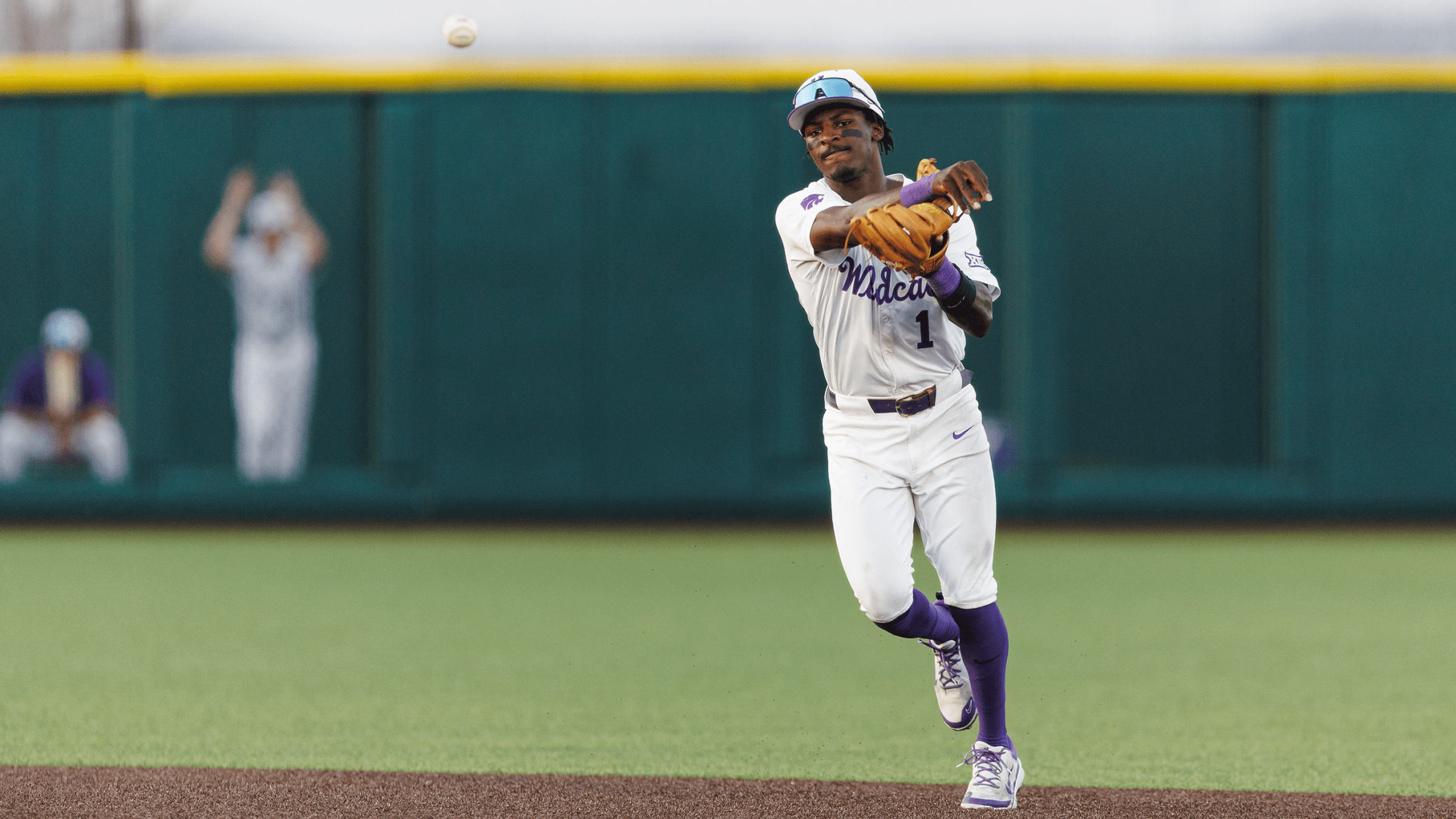 Kansas State shortstop Dee Kennedy throws a ball towards first base
