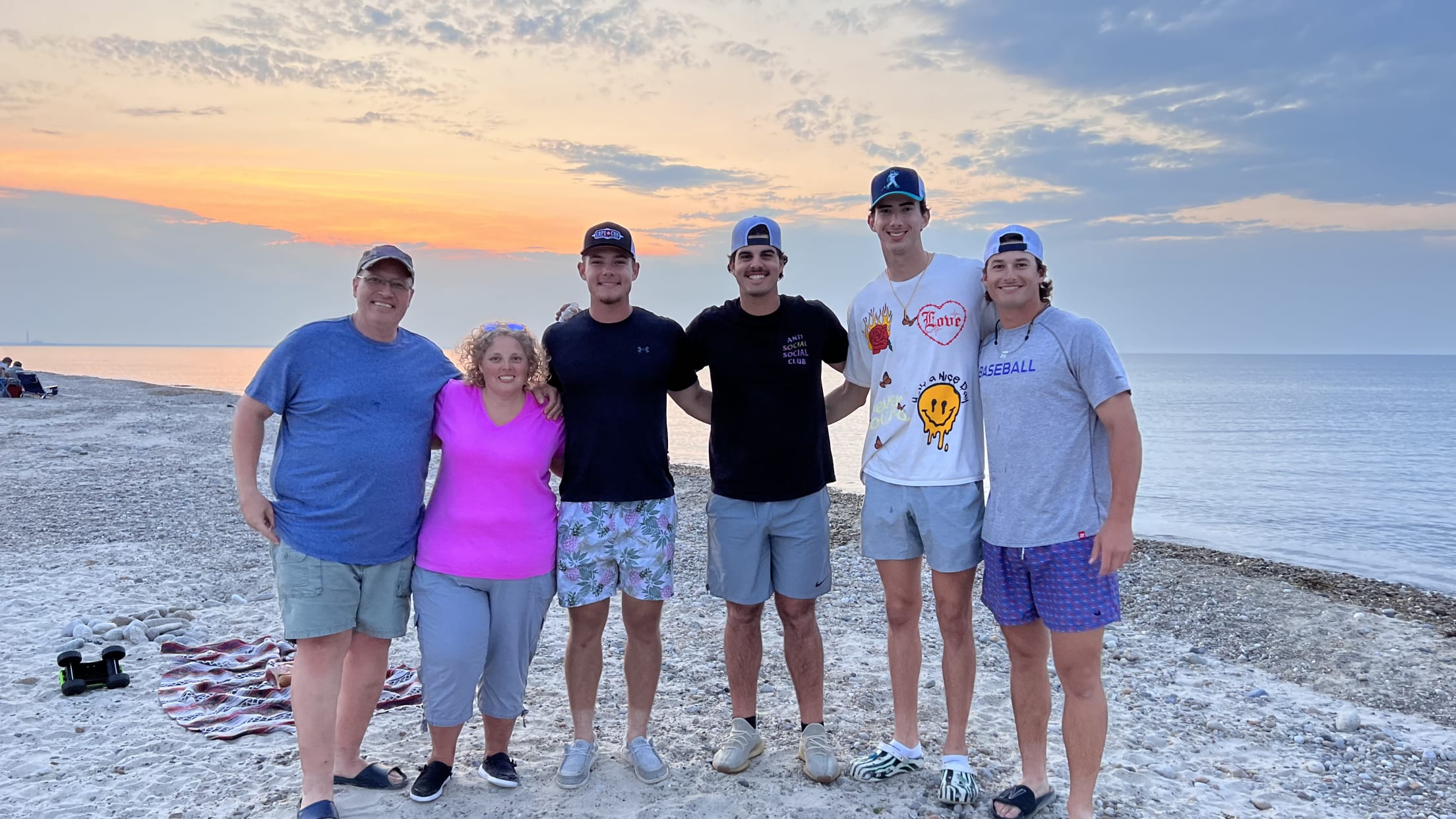 Wareham players pose with their host family in front of the ocean.