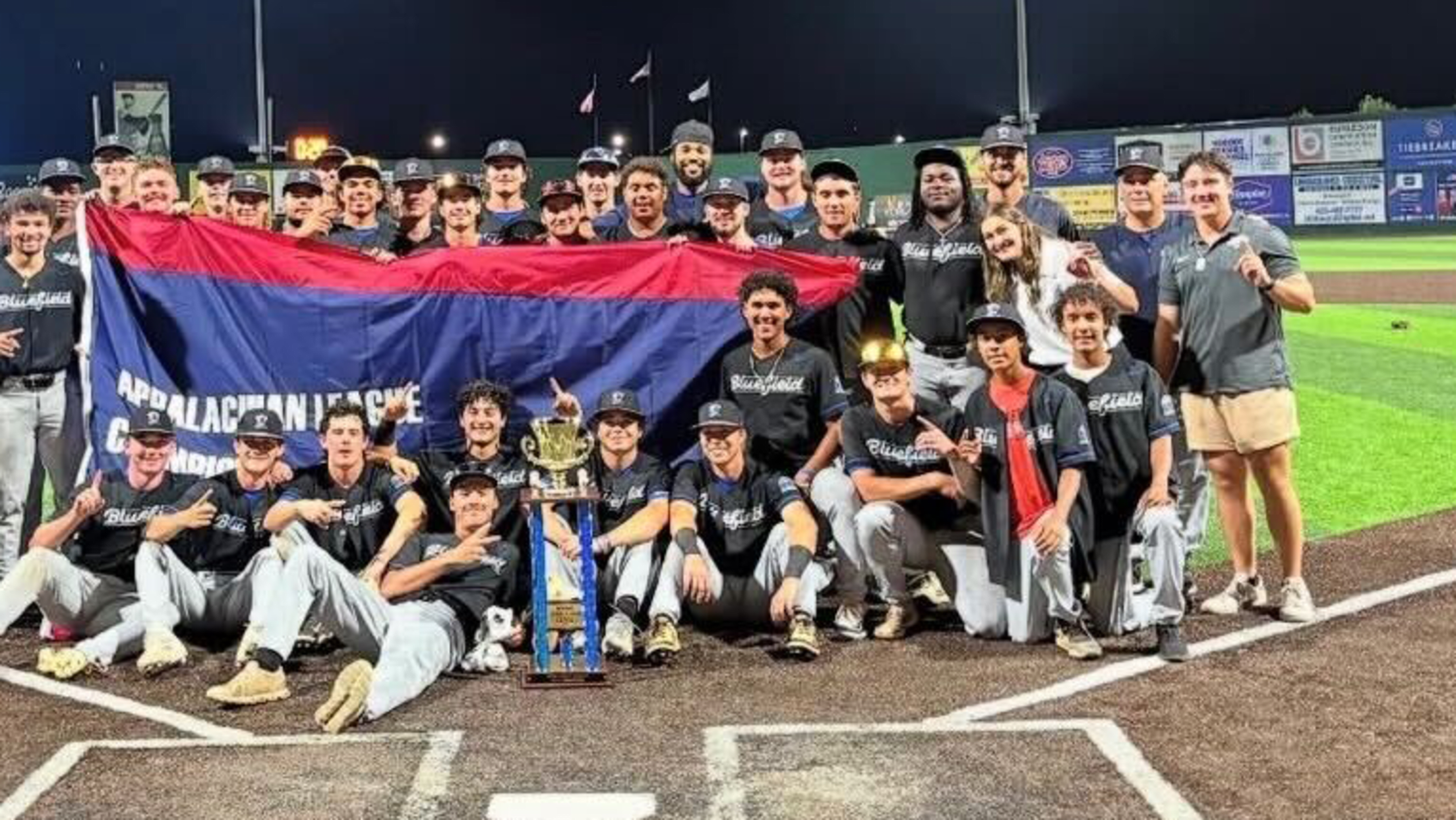 The Bluefield Ridge Runners celebrate at TVA Credit Union Ballpark in Johnson City, Tenn., after winning the 2025 Appalachian League Champinoship. The team displays a banner and pose with the trophy.