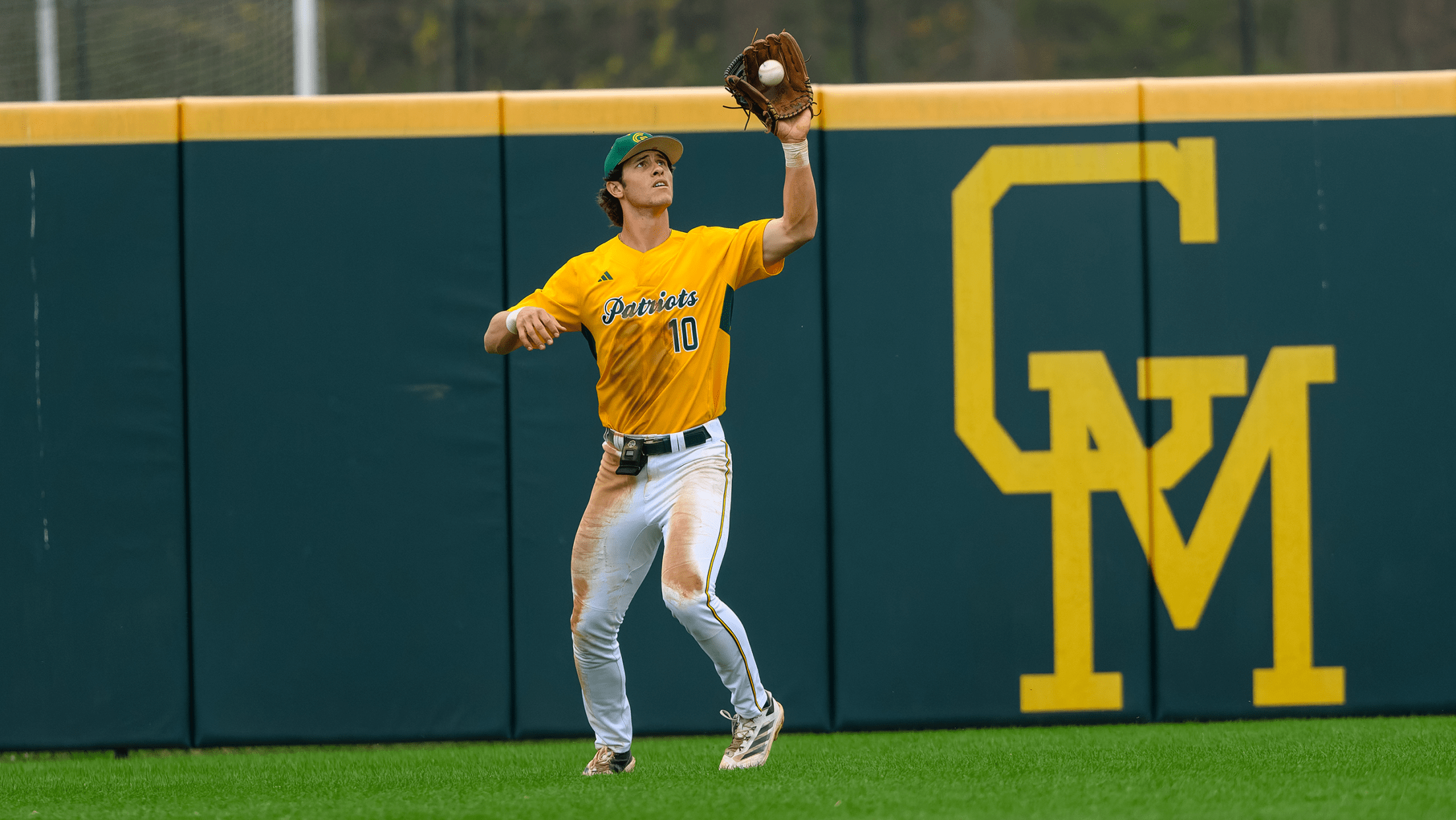George Mason outfielder James Quinn-Irons watches a ball into his glove to make a catch.