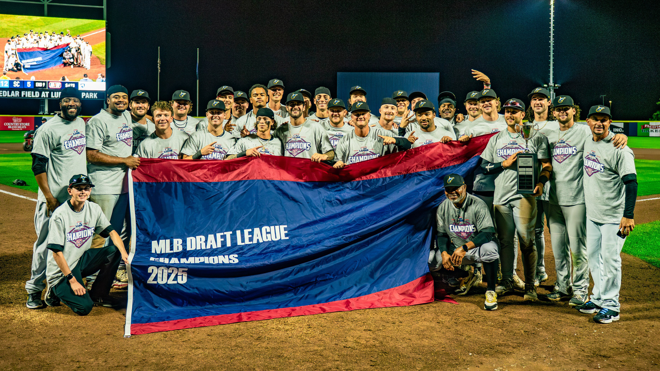 The West Virginia Black Bears pose for a photo with the 2025 MLB Draft League Champions banner.
