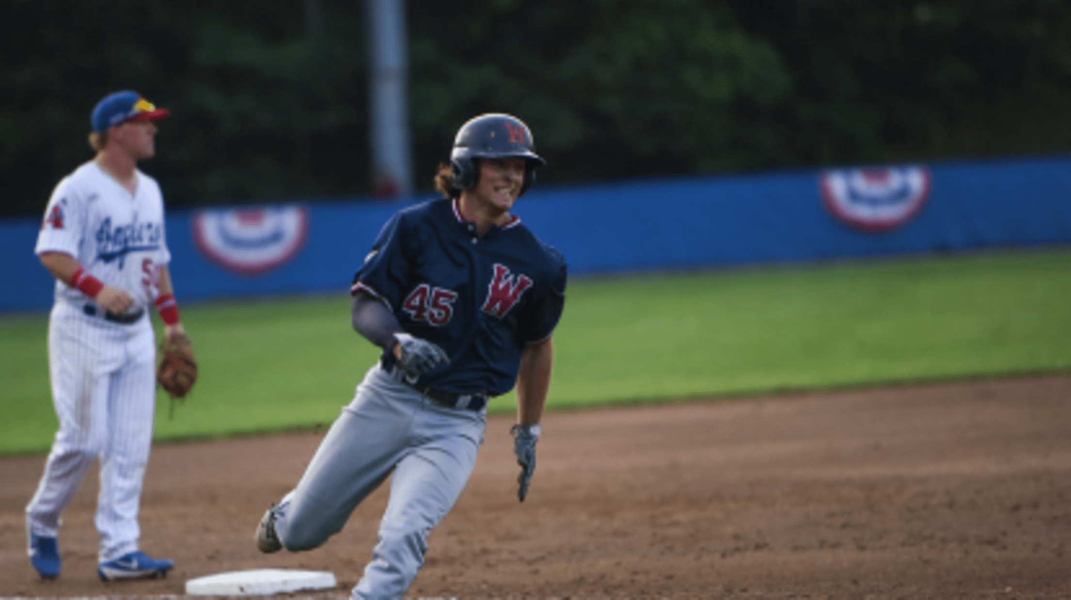 A Wareham Gateman player rounds third base and heads for home with a focuses grimace facing home plate.