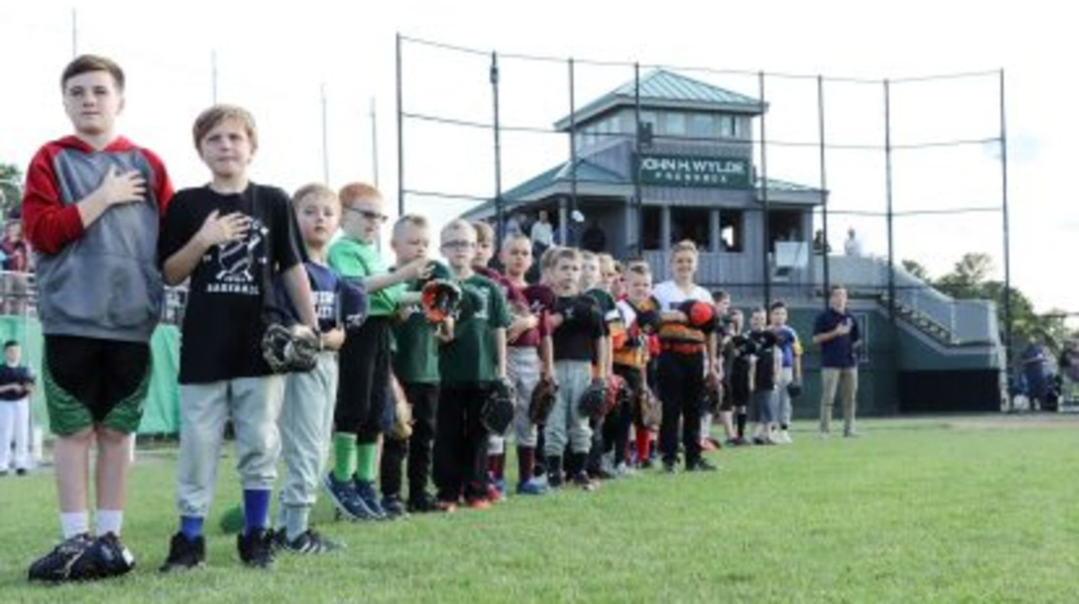 Children line up on the field for the national anthem with the Gatemen Field of Dreams program.
