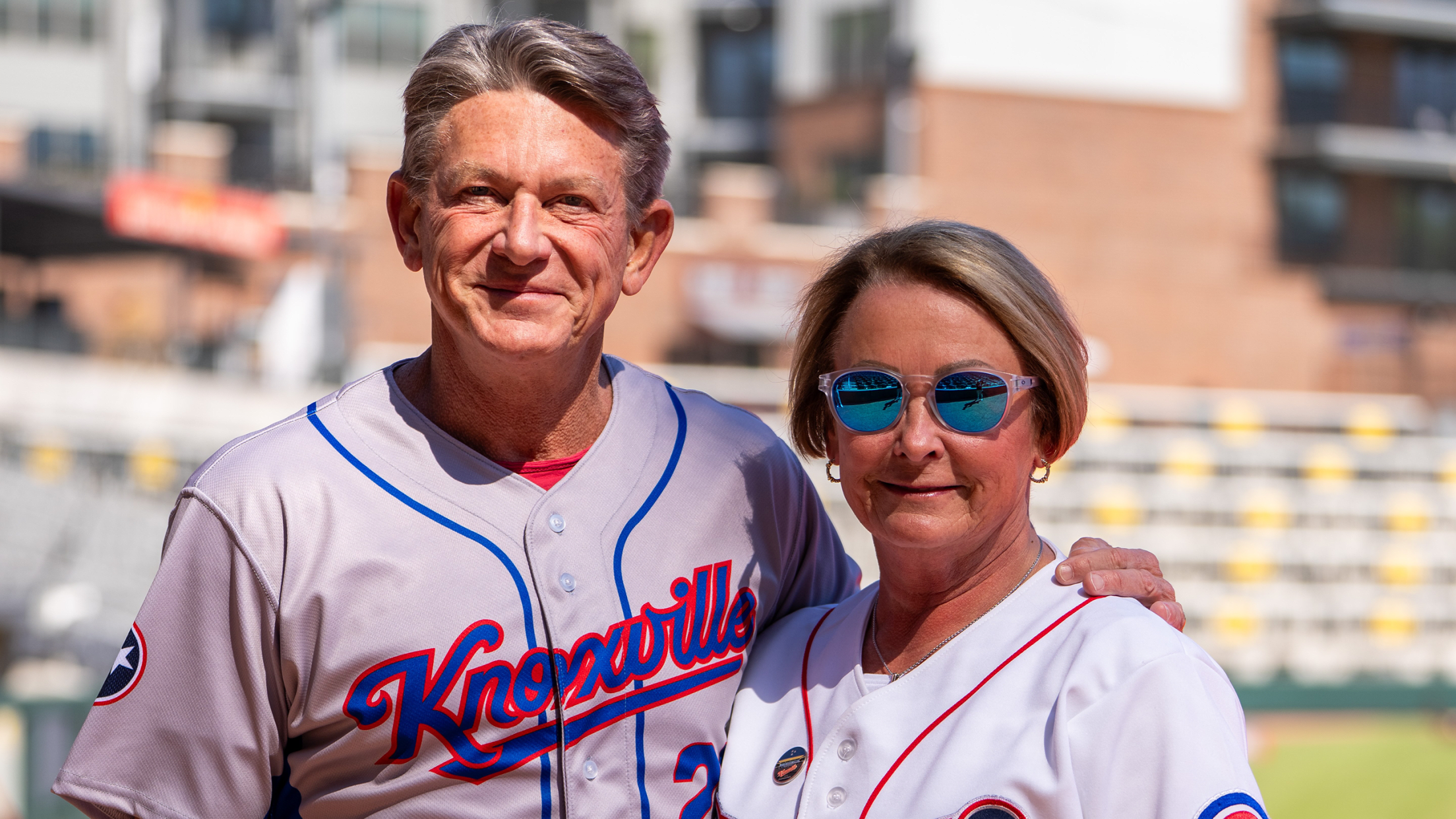 Randy and Jenny Boyd pose for a photo at Truist Park wearing Knoxville Smokies jerseys.