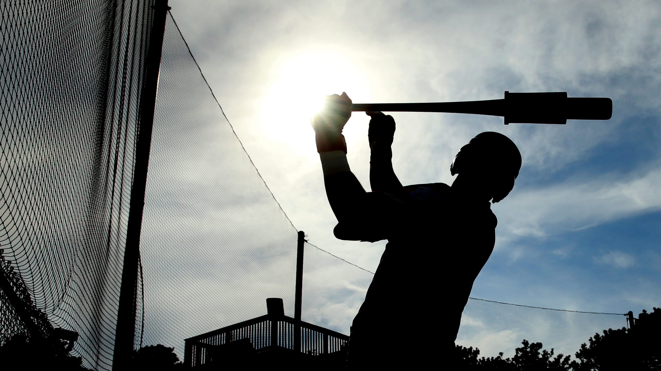 Harwich player makes swing cast in shadow.
