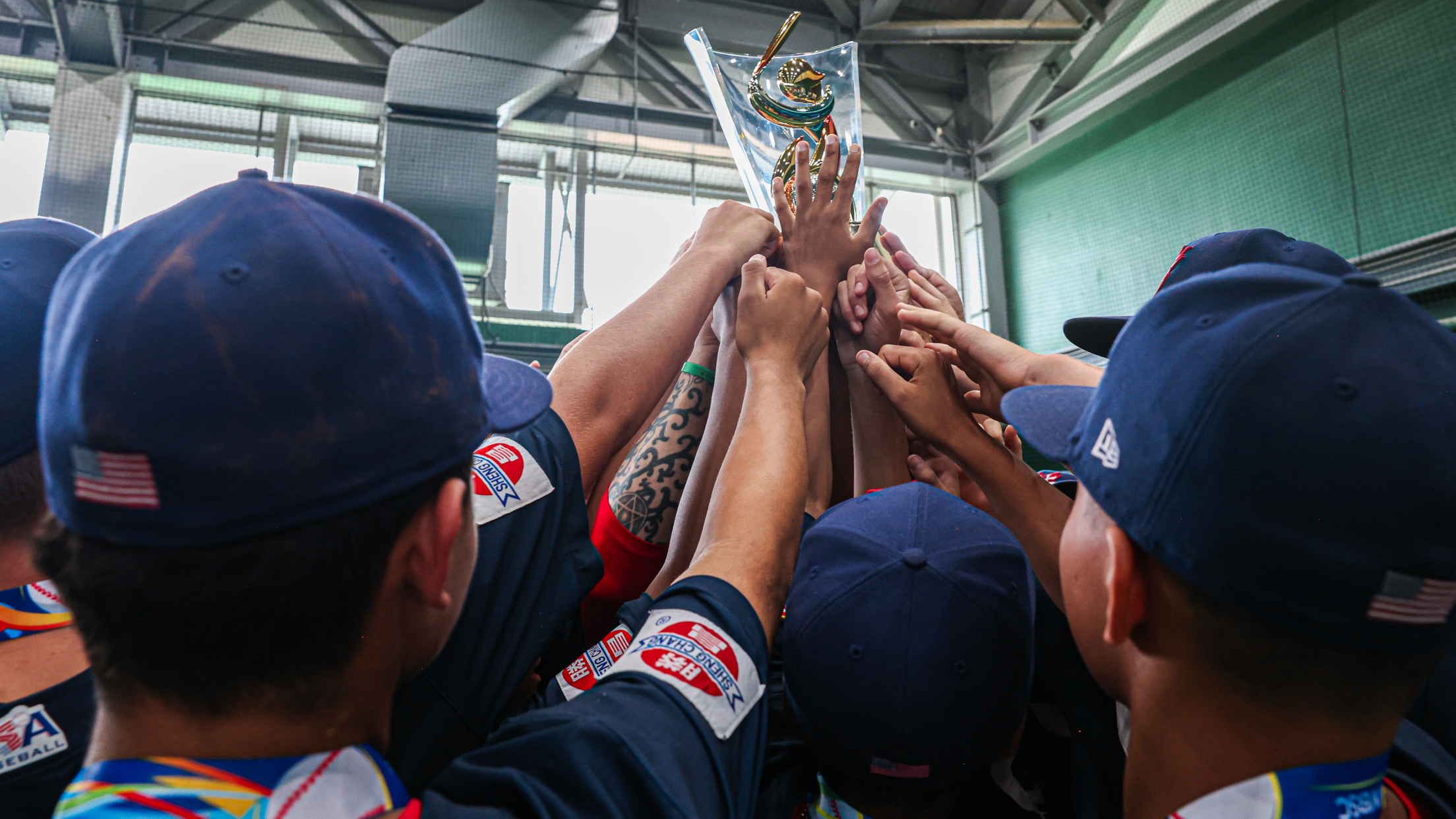 A group of baseball players hoisting a trophy in the air