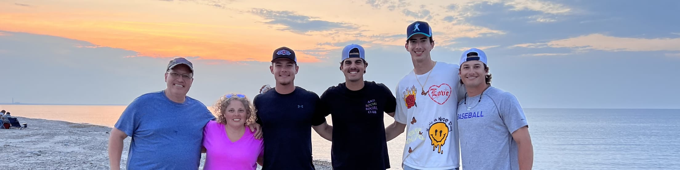 Wareham players pose with their host family in front of the ocean.
