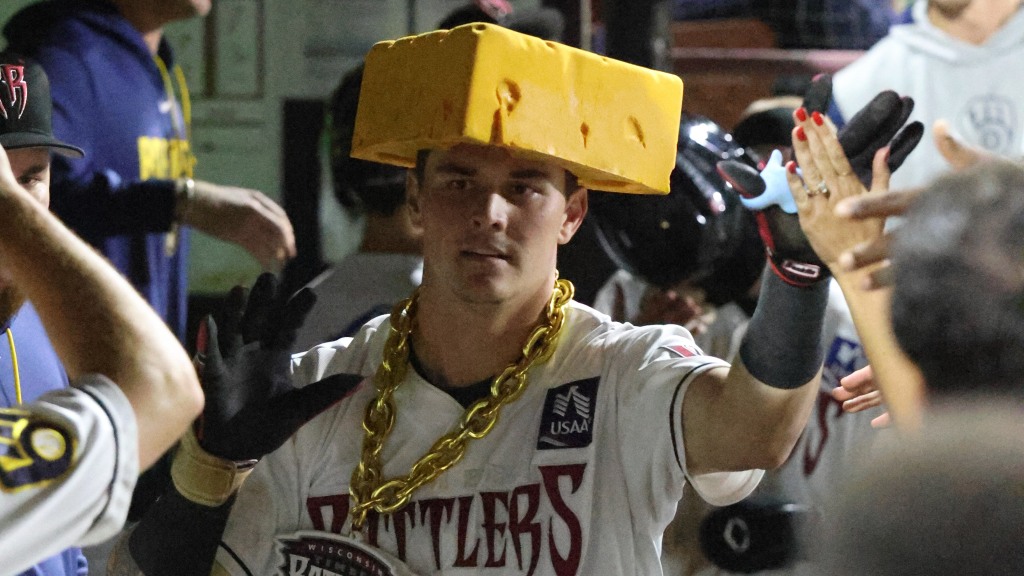 Eric Bitonti is greeted by his Wisconsin Timber Rattlers teammates in the dugout after hitting his 24th home run of the season to set a new single-season team record.