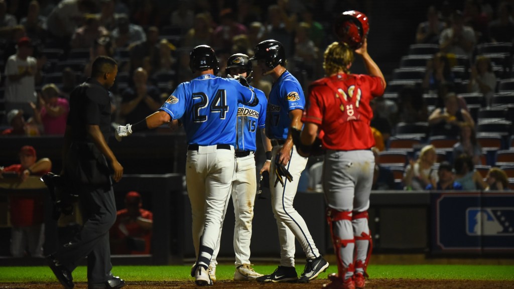 Nolan Schubart celebrates at home with Aaron Walton and Jace LaViolette after hitting a three-run home run. LaViolette homered two innings later.
