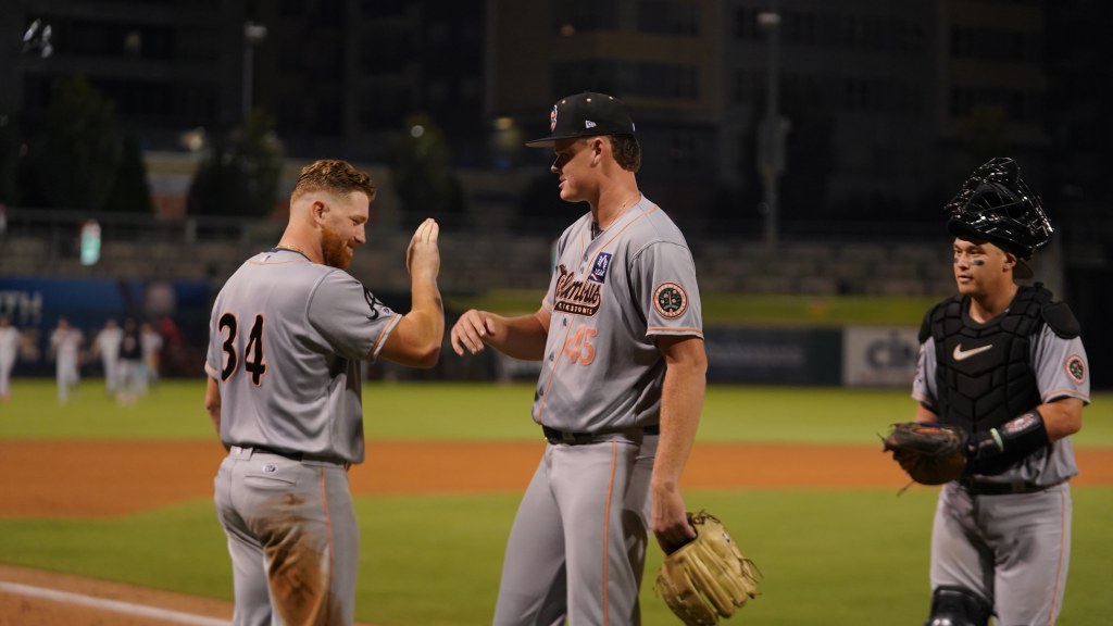 Garrett Baumann congratulated by teammate Adam Zebrowski (34) after his complete game on Friday.