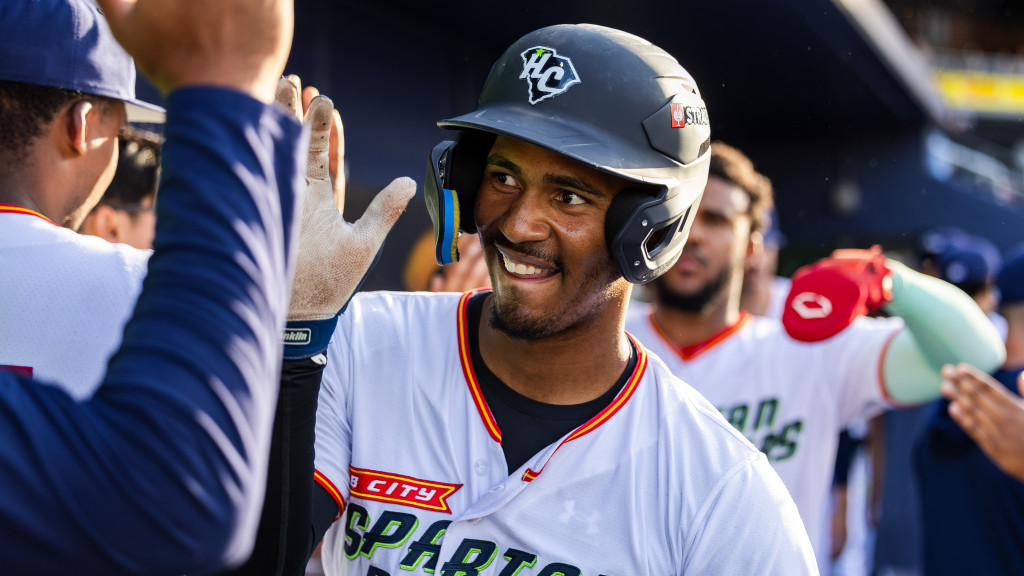 Yeison Morrobel receives high-fives in the Spartanburgers dugout.