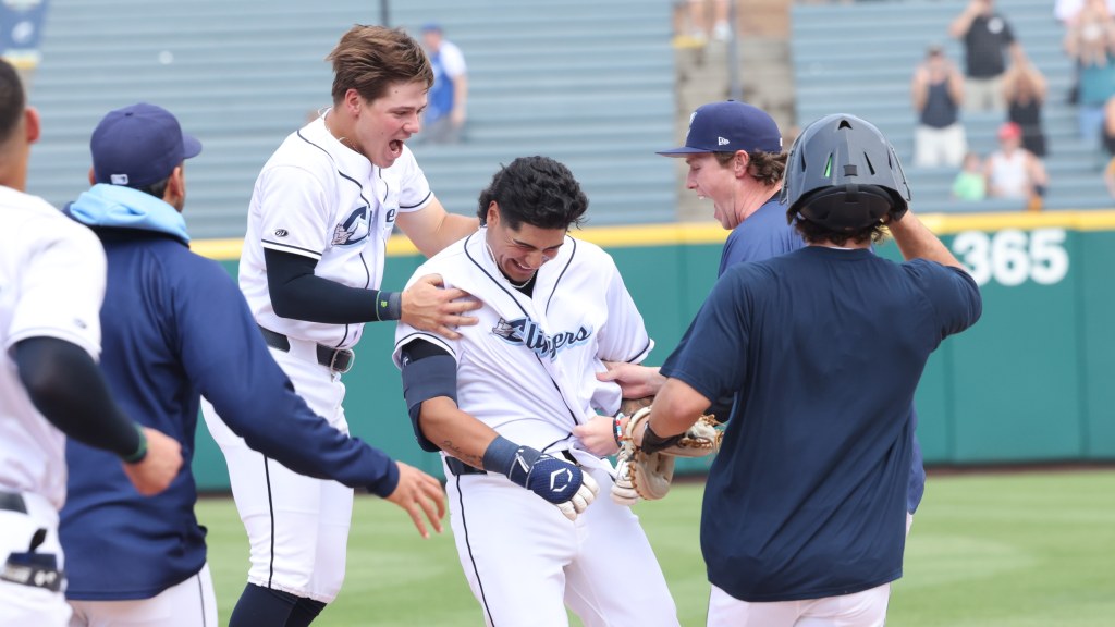 Ralphy Velazquez is mobbed by his teammates after his walk-off single Sunday