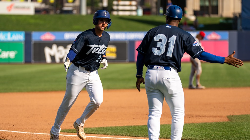Griffin Lockwood-Powell receives congratulations from third base coach Johan Garcia after hitting the first of his two home runs in Saturday's 4-3 game one win.