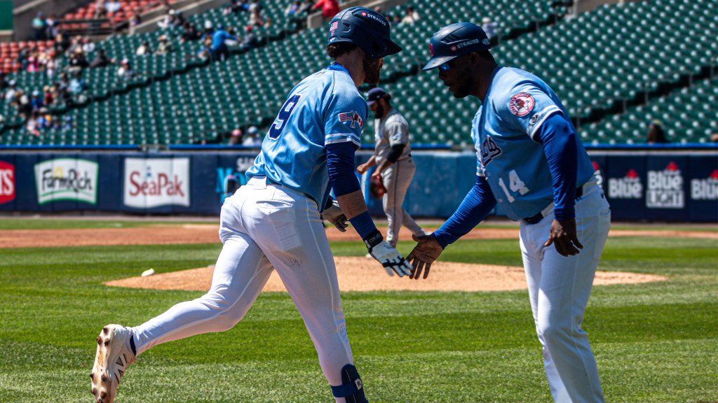 R.J. Schreck is congratulated by bench coach Cesar Martin following his 2nd inning home run.