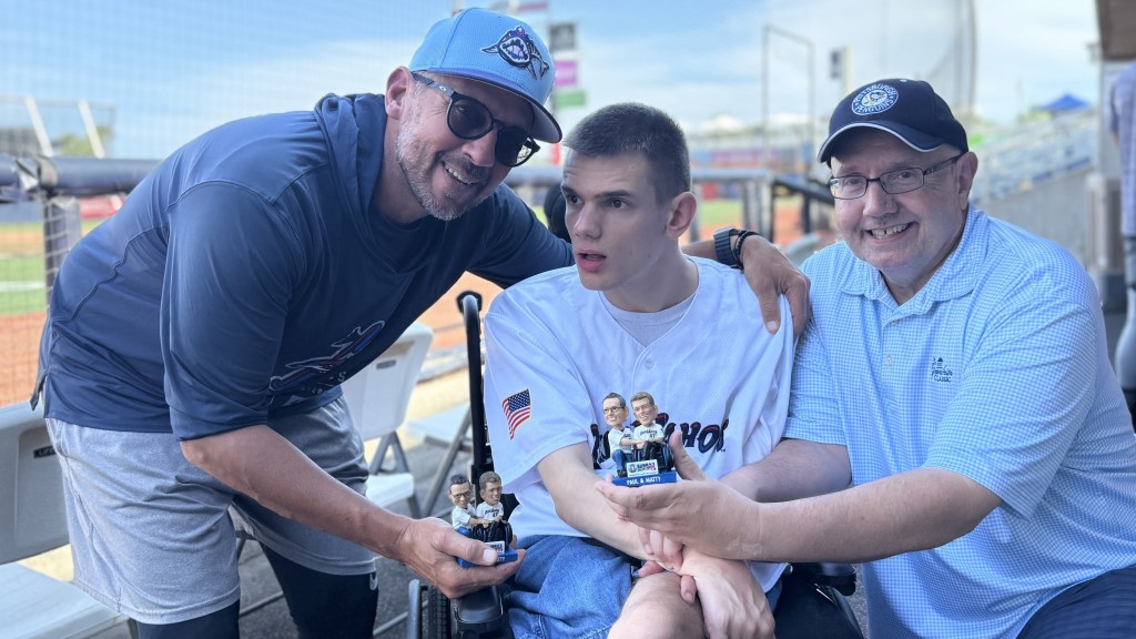 Blue Wahoos manager Nelson Prada visits with Matthew Chestnutt, special needs son of Paul Chestnutt during pregame workout Sept. 8.