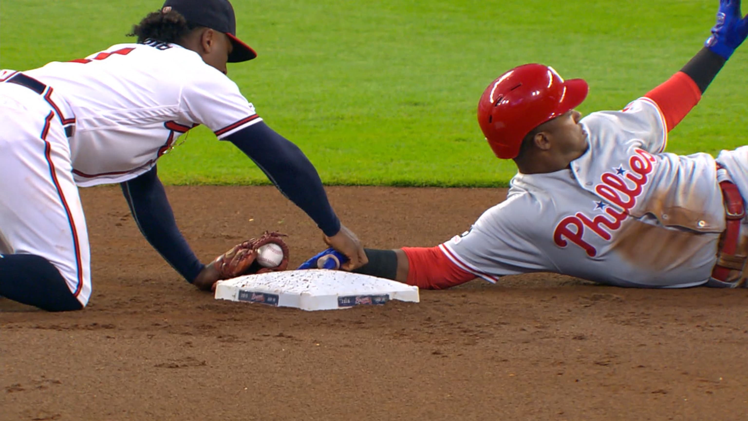 Ozzie Albies pushes Jean Segura hand off base