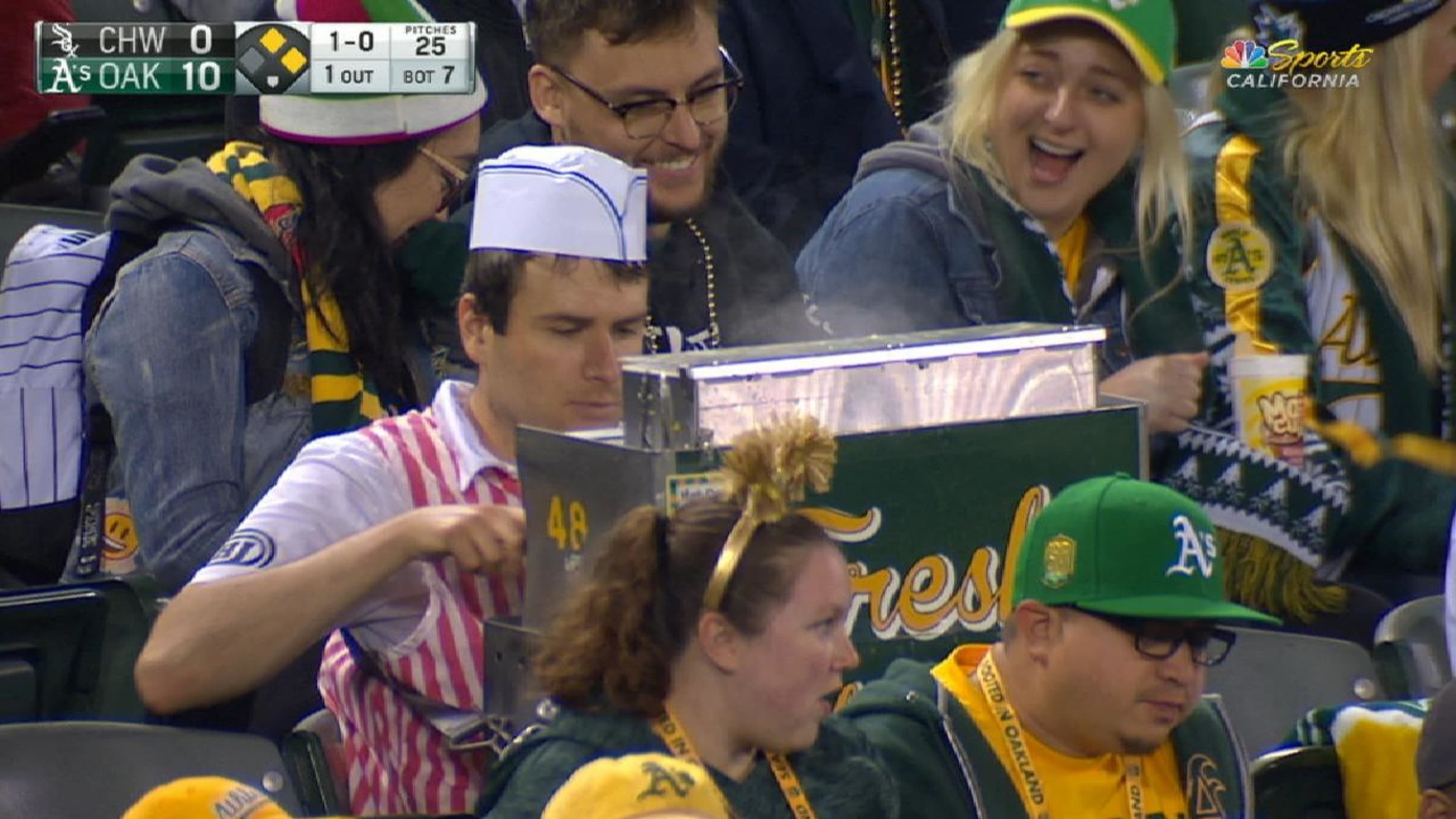 An A's hot dog vendor took a seat among some fans and kept working