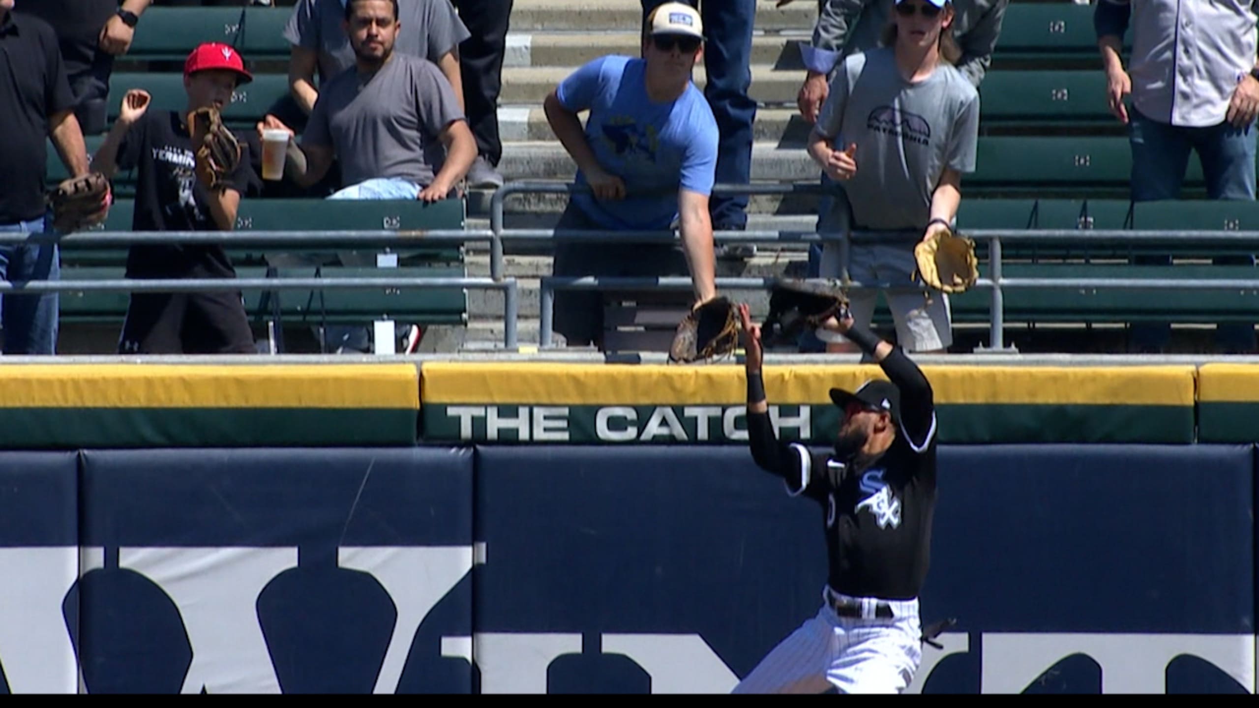 Chicago White Sox Billy Hamilton climbs the outfield wall to give