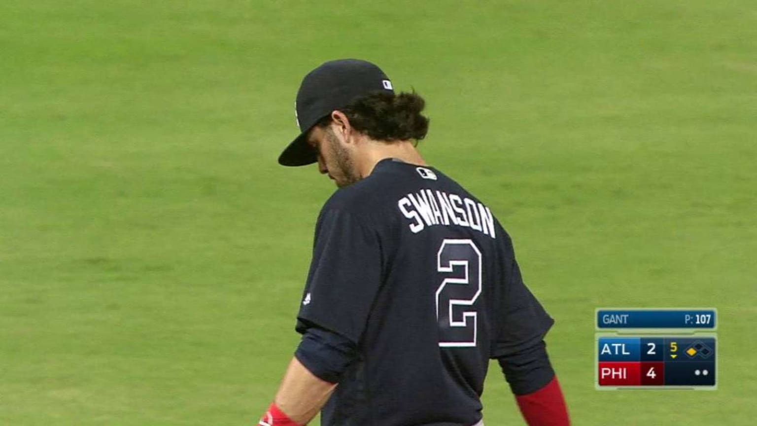 Dansby Swanson slides to the ground to stop Ryan Howard's grounder and...