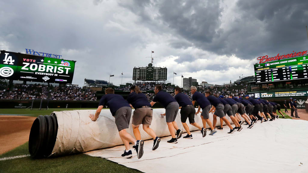 The Wrigley Field grounds crew prepares the infield tarp for an approaching storm before a game between the Dodgers and Cubs on Monday, June 18, 2018, in Chicago.