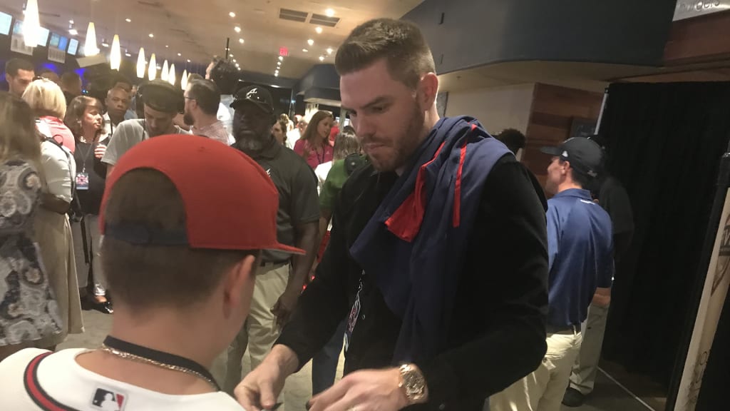 Freddie Freeman signs an autograph for a young Braves fan.