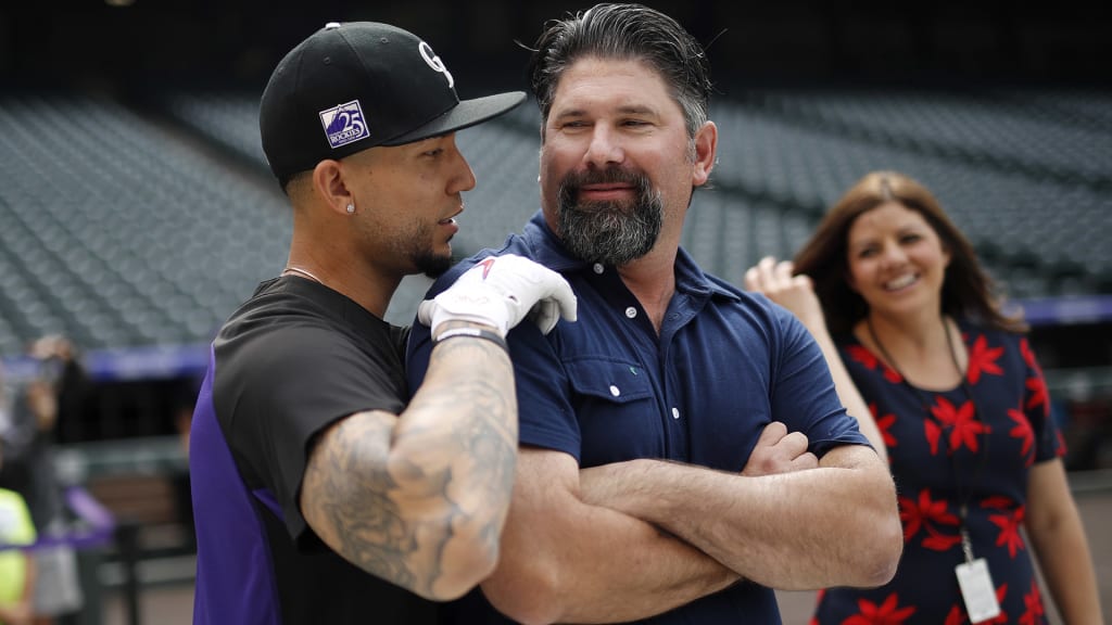 Colorado Rockies right fielder Carlos Gonzalez, left, greets former teammate Todd Helton, center, during batting practice with Rockies television announcer Jenny Cavner looking on before a baseball game against the Miami Marlins, Friday, June 22, 2018, in Denver. (AP Photo/David Zalubowski)