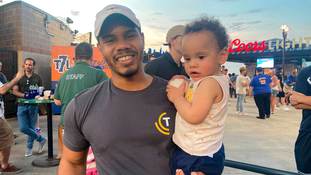 Alan Alcantara with his 1-year-old son Levi, holding the Starling Marte home run ball. (Jake Seiner/AP)