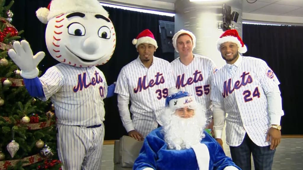 New York Mets outfielder Brandon Nimmo, center, dressed as Santa