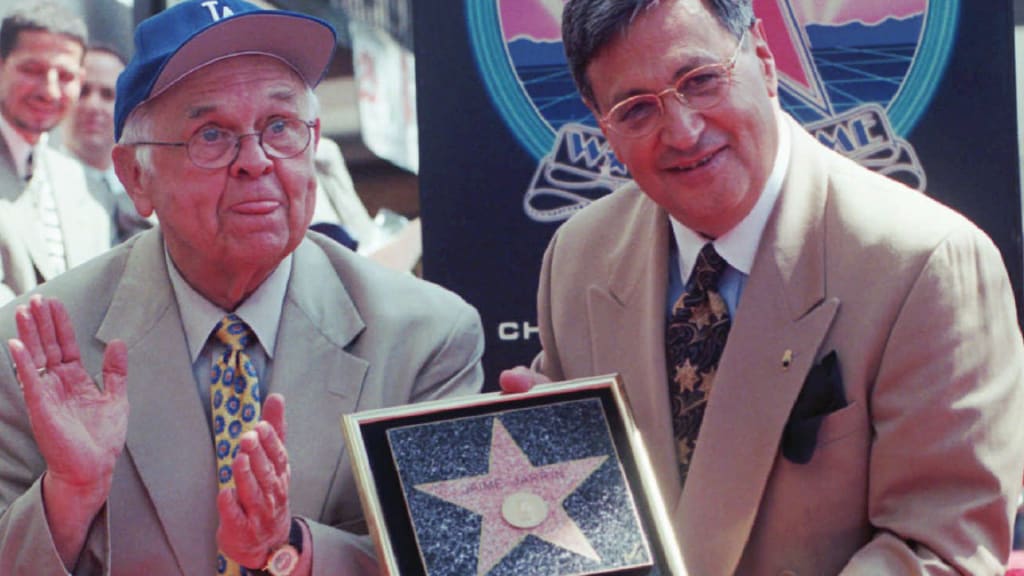 Jaime Jarrín (right) displays his plaque on the Hollywood Walk of Fame in 1998. (AP)