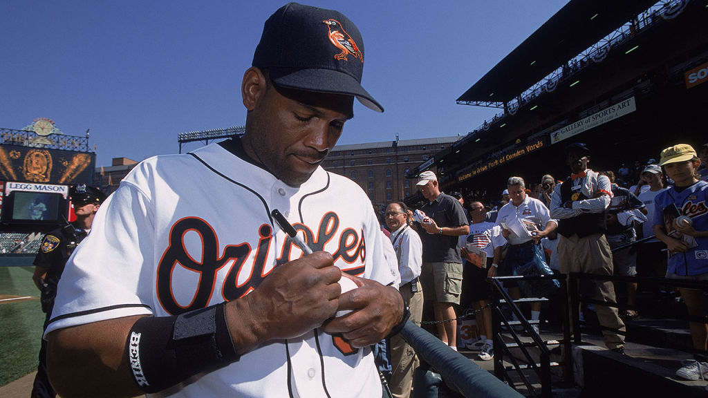 Tim Raines signs a baseball for a fan in Baltimore late during the 2001 season. (Getty)